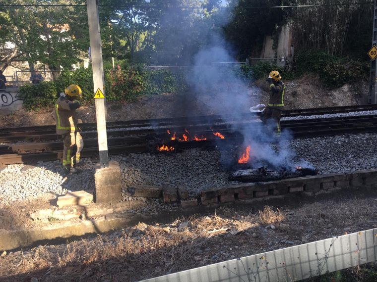 Els bombers aparten el tronc i els neumàtics incendiats per restablir la circulació de trens