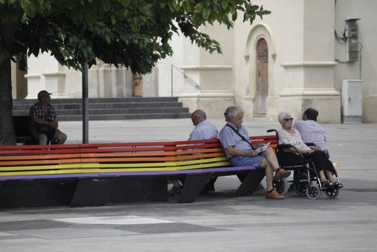 Un grup de persones asseguts al banc de la plaça d'Abat Oliba. FOTO: Arxiu. 