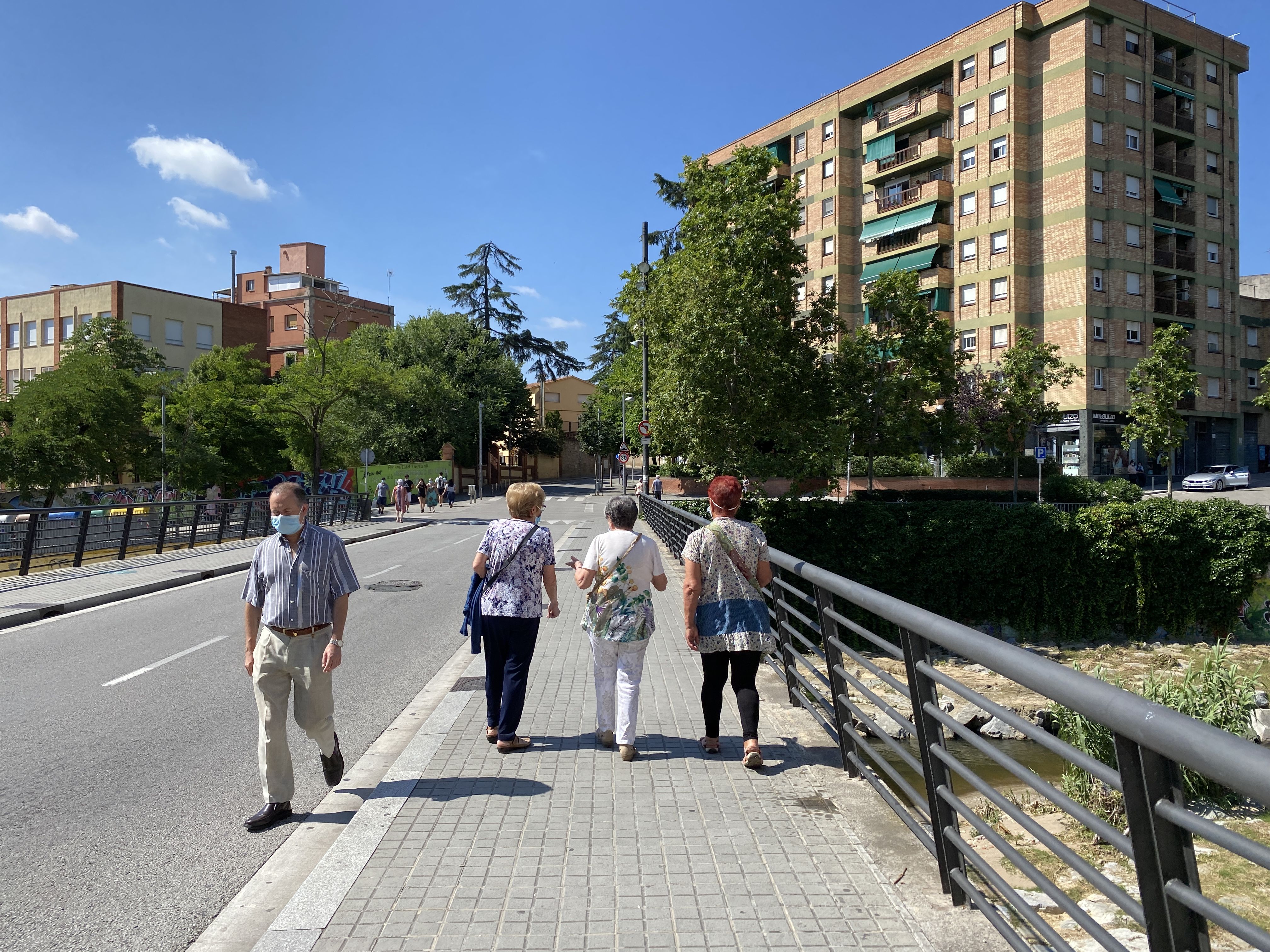 Veïns i veïnes passejant pels carrers de la ciutat