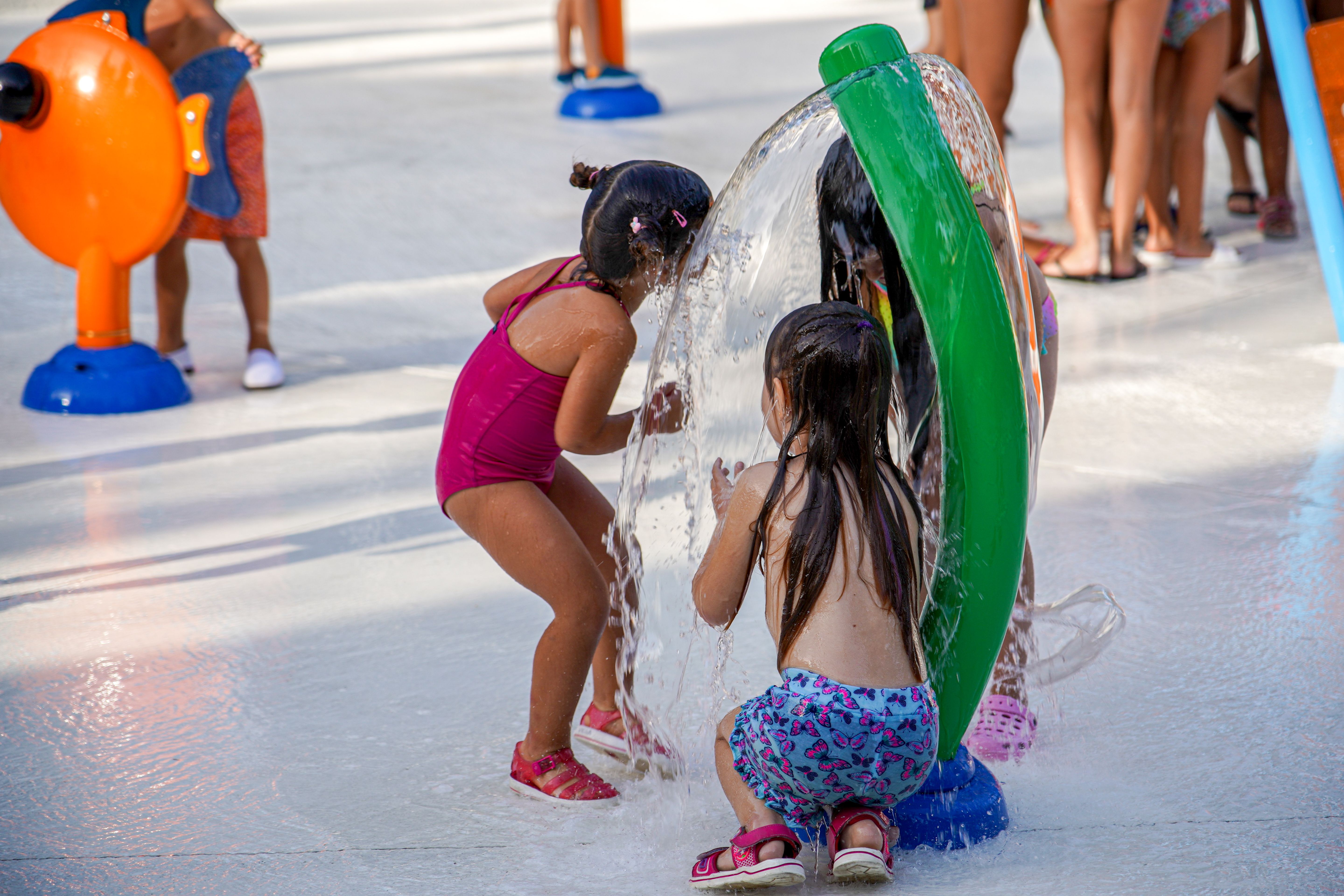 Dues nenes juguen als jocs d'aigua del Parc Cordelles. FOTO: Mònica García