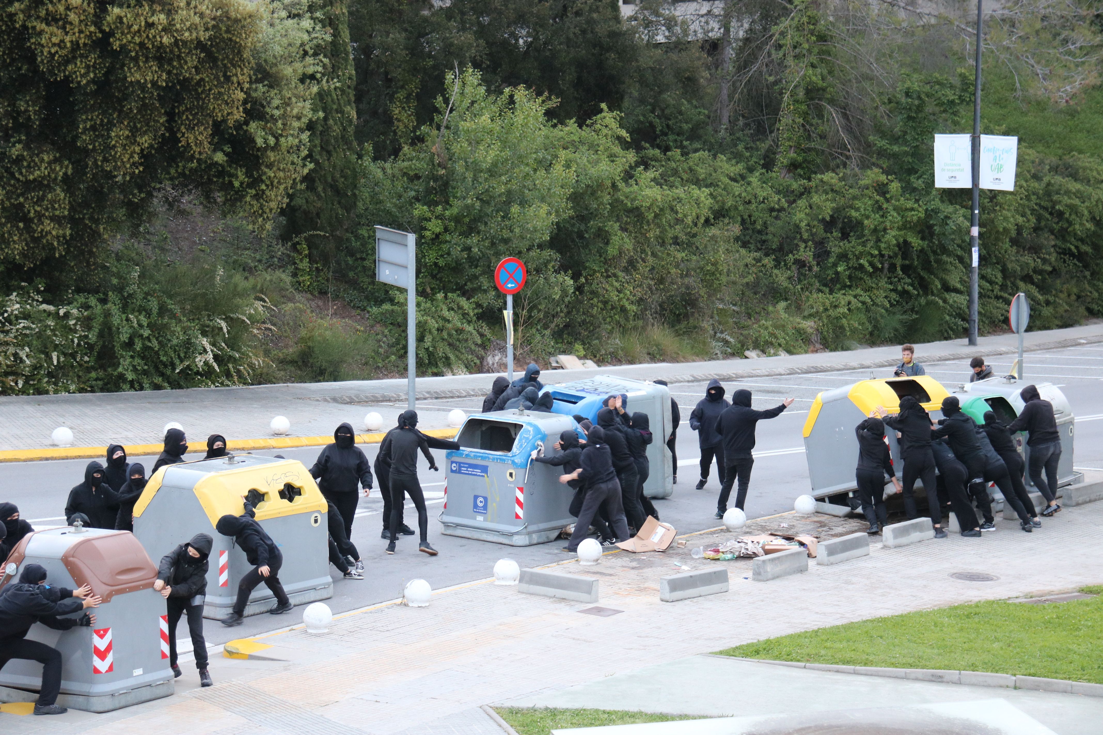 Un grup de manifestants mou contenidors a la UAB. FOTO: Albert Segura / ACN