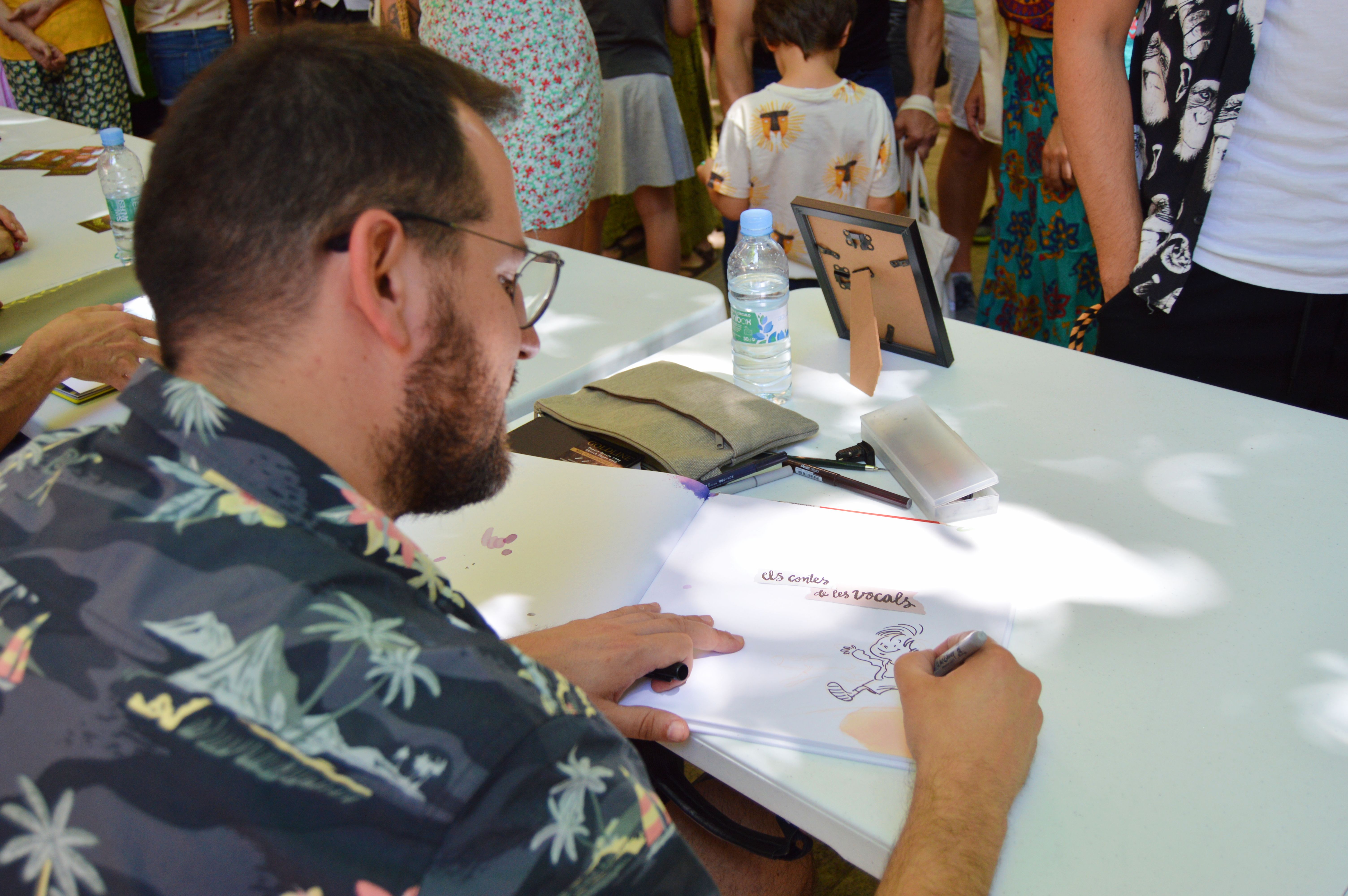 Toni Galmés dibuixant una signatura a la Festa de la Il·lustració de l'Aranya. FOTO: Nora Muñoz Otero