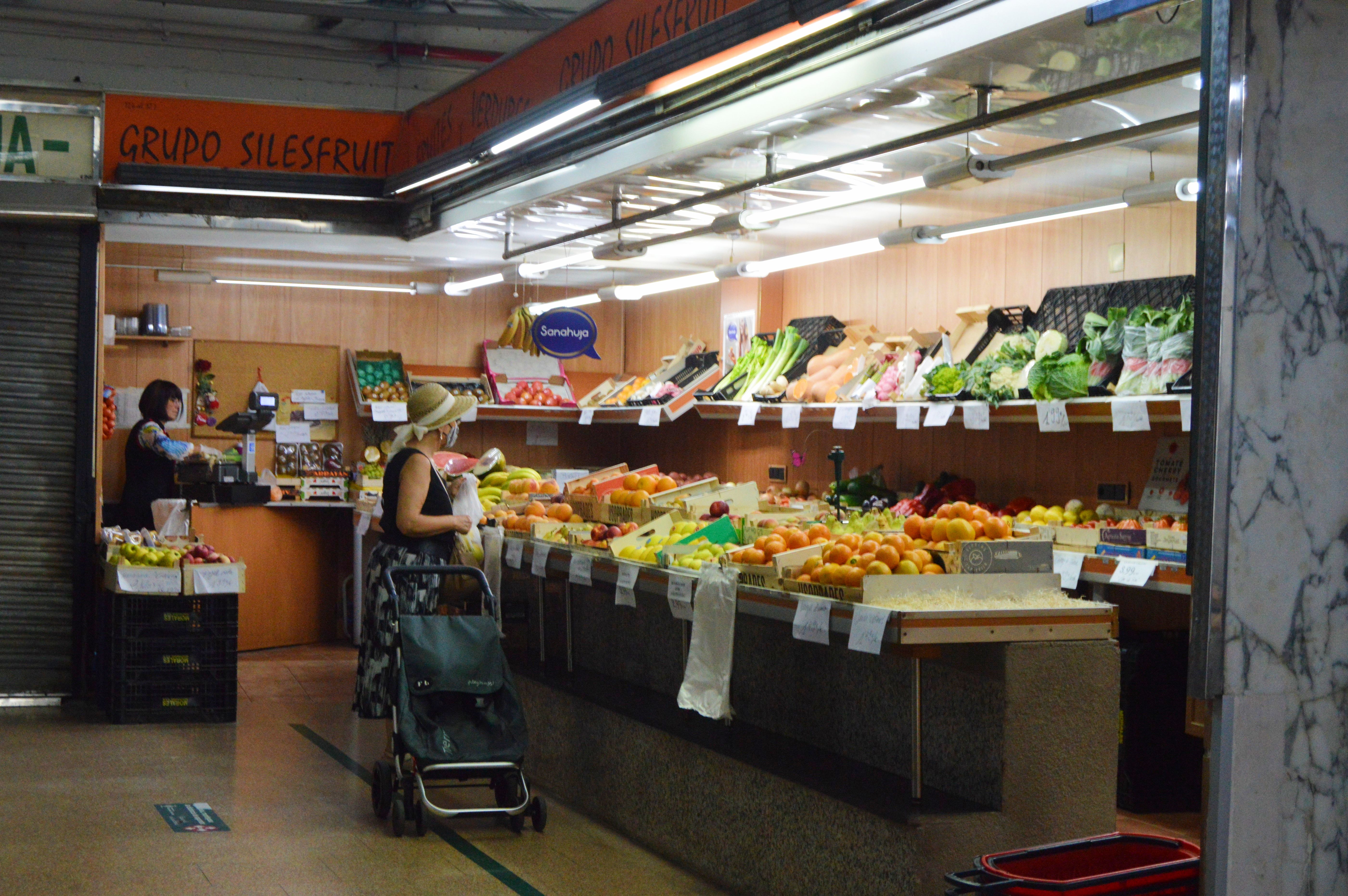 Veïns fent la compra al Mercat de les Fontetes un matí d'agost. FOTO: Nora Muñoz Otero