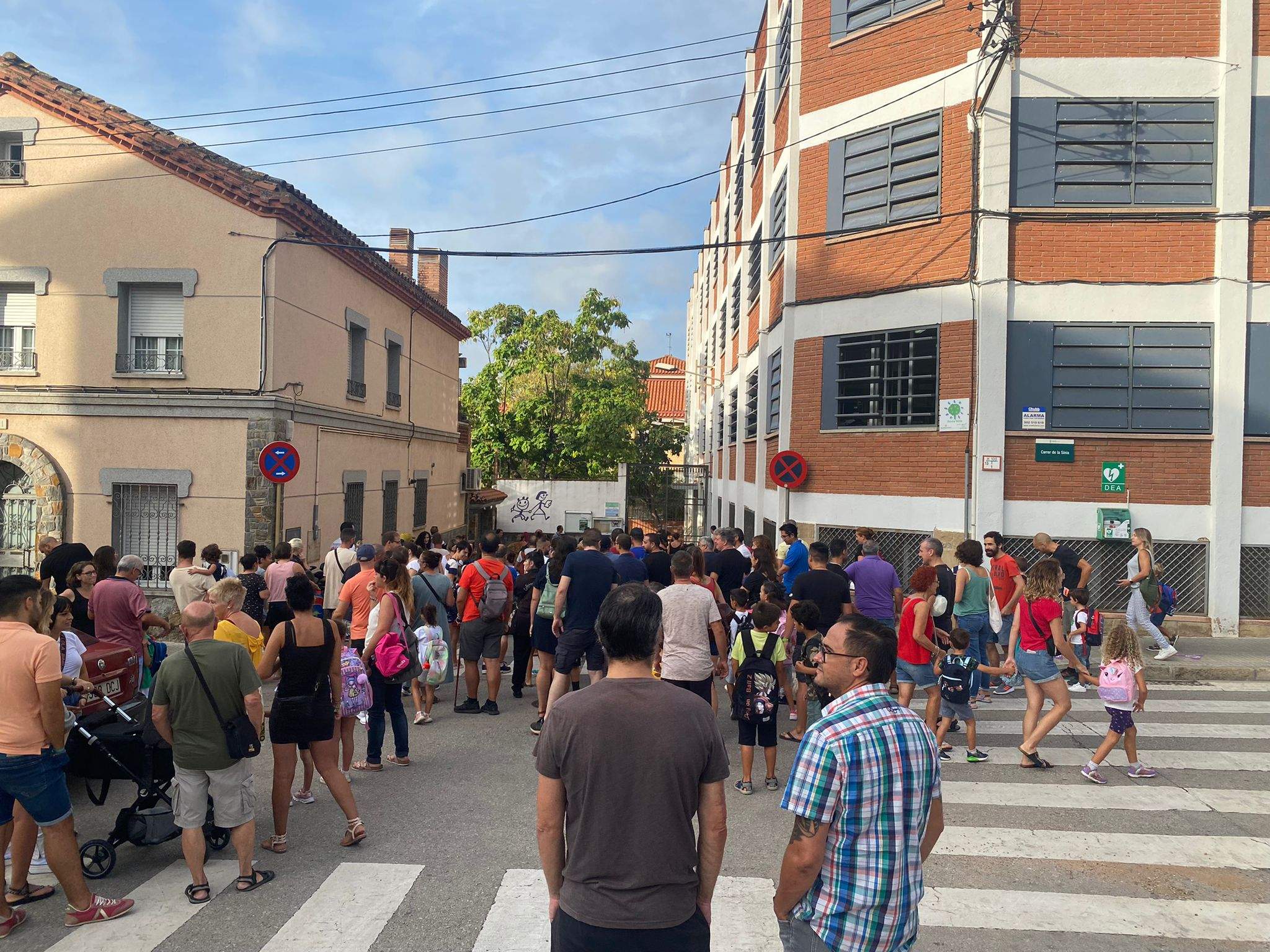 Alumnes, pares i mares esperant per entrar al col·legi La Sínia de Cerdanyola aquest matí. FOTO: Mónica GM