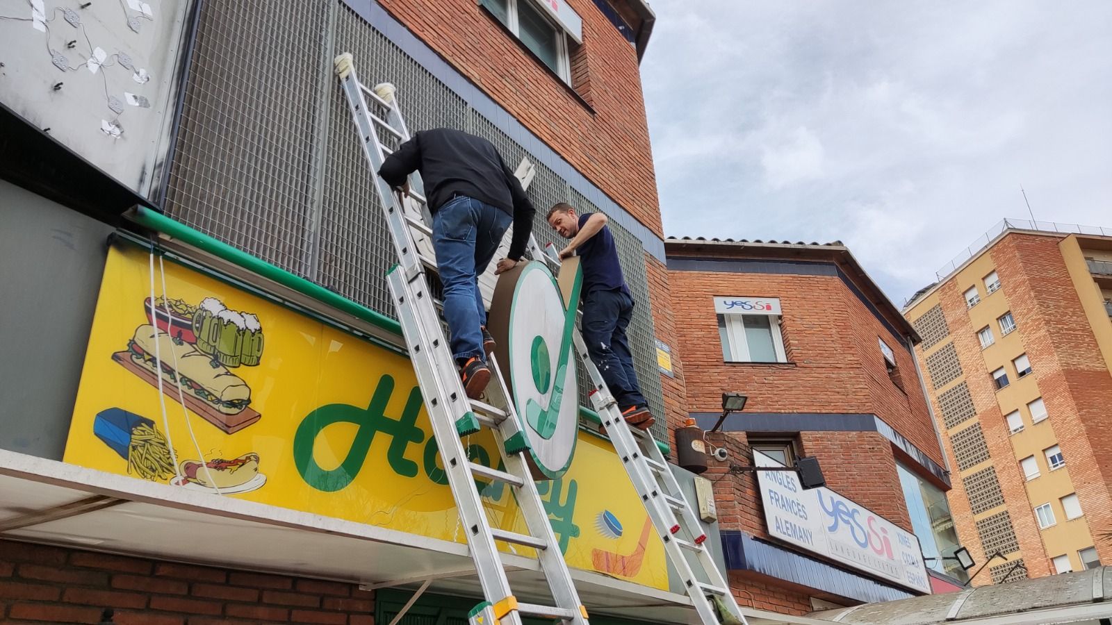 Moment del desmuntatge dels cartells de l'antic Bar Hockey. FOTO: Cedida