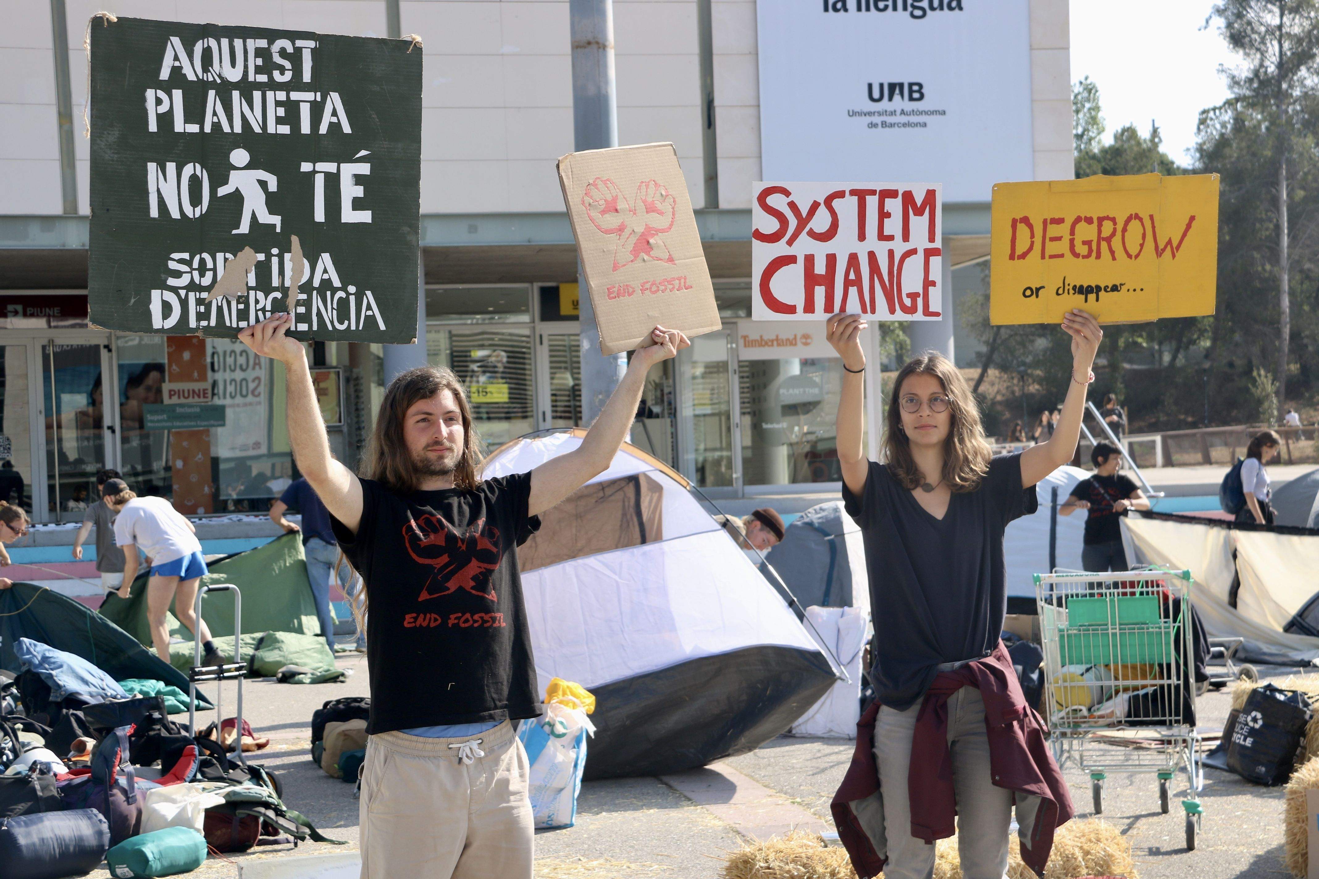 Dos joves sostenen cartells en l'acció del col·lectiu End Fossil Barcelona a la UAB. FOTO: Albert Segura (ACN) Dos joves sostenen cartells en l'acció del col·lectiu End Fossil Barcelona a la UAB. FOTO: Albert Segura (ACN)