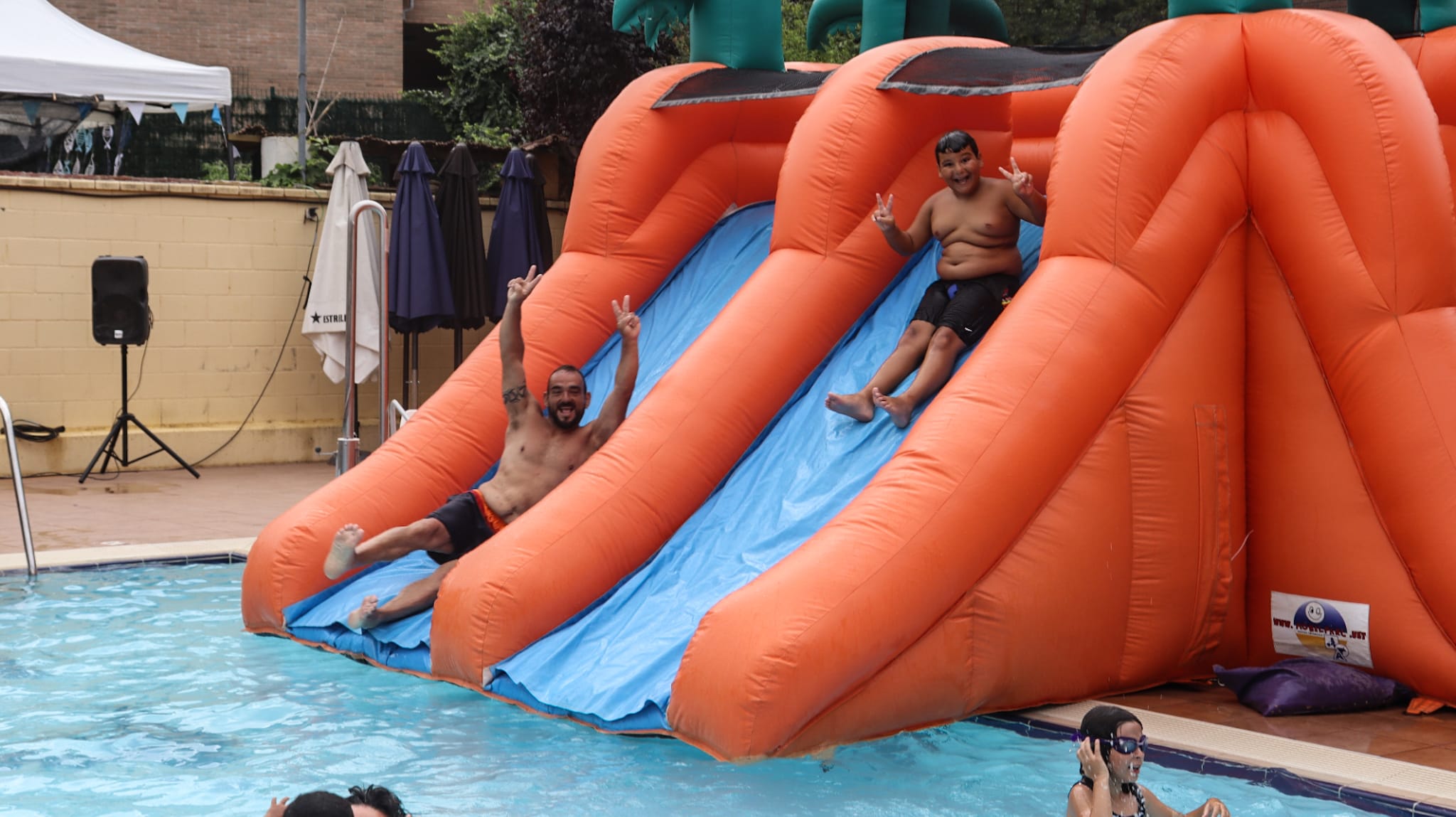 Pare i fill llençant-se en un dels tobogans de la Gran Festa Infantil de l'aigua. FOTO: Marc Mata 