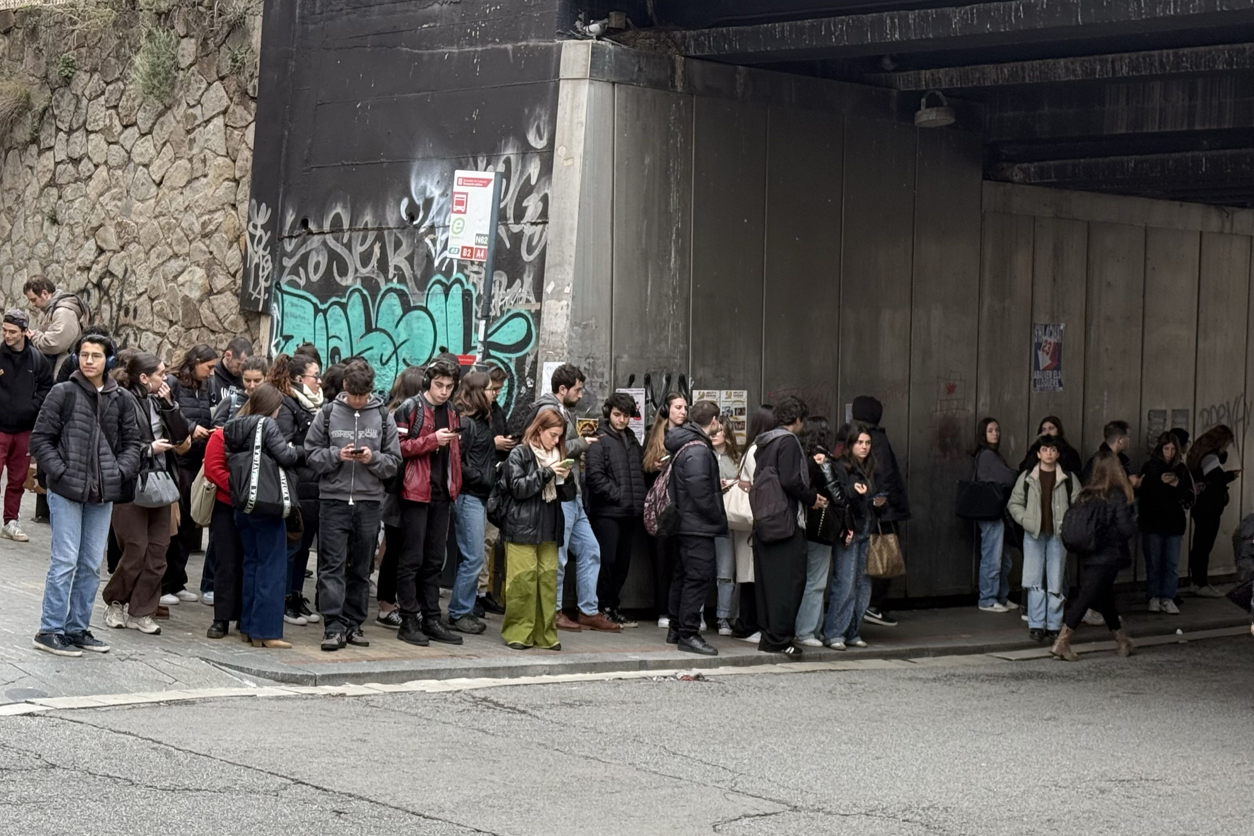 Usuaris esperant l'arribada del bus E3 sota el pont de l'estació de Renfe a Cerdanyola. FOTO: ACN Usuaris esperant l'arribada del bus E3 sota el pont de l'estació de Renfe a Cerdanyola. FOTO: ACN