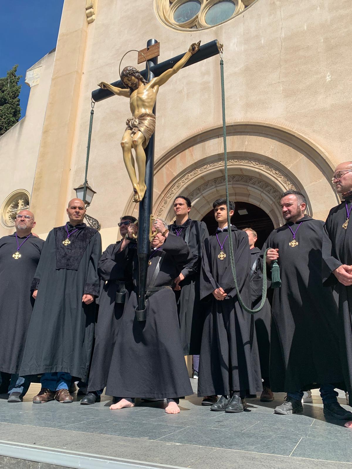 La imatge de Crist i els portadors davant l'església de Sant Martí