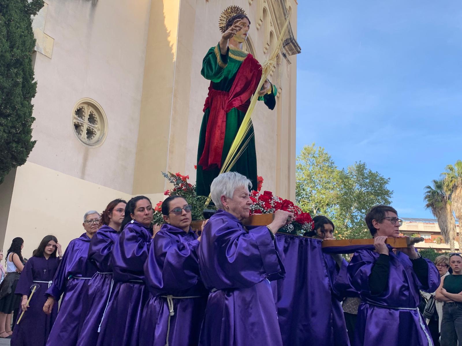 La figura de Sant Joan Evangelista sostinguda per un grup de portadores