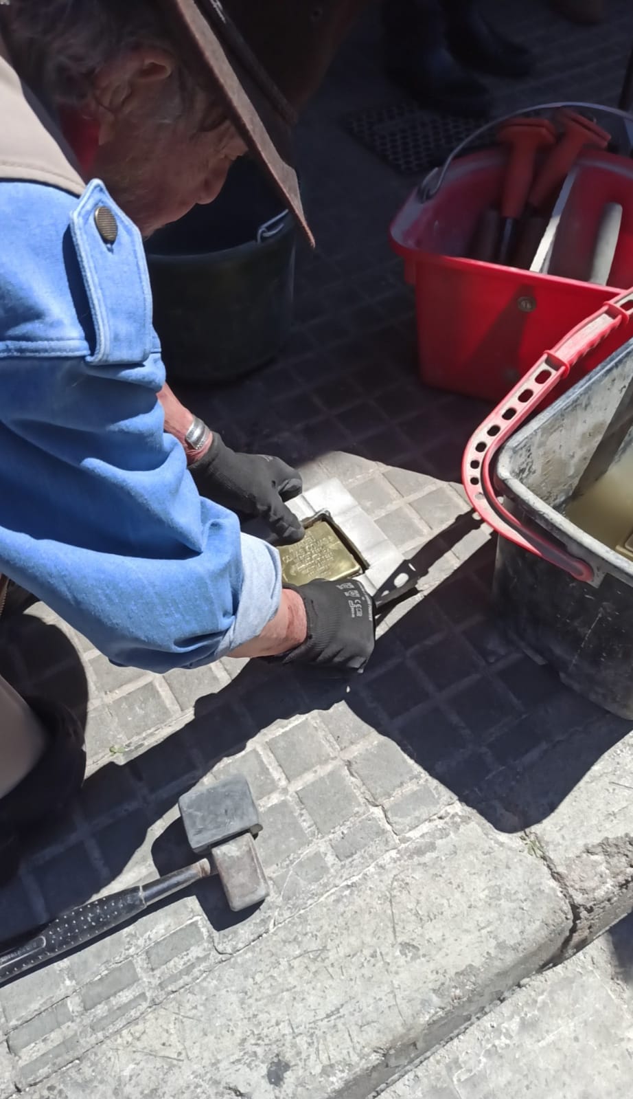 L'artista Gunter Demnig, creador del memorial Stolpersteine, col·loca la primera pedra de memòria de Cerdanyola. Foto: Danny Romero.