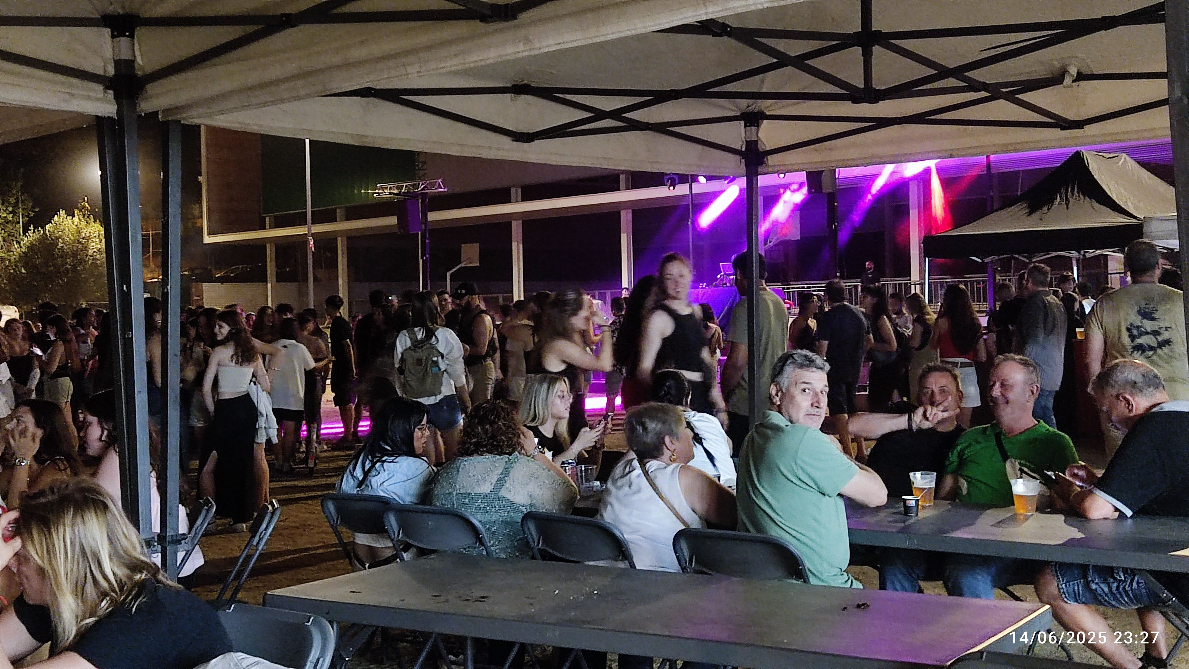 Veïns i veïnes gaudint de les activitats infantils i musicals durant la Festa Major del barri de Sant Martí del Sot de Can Xarau.