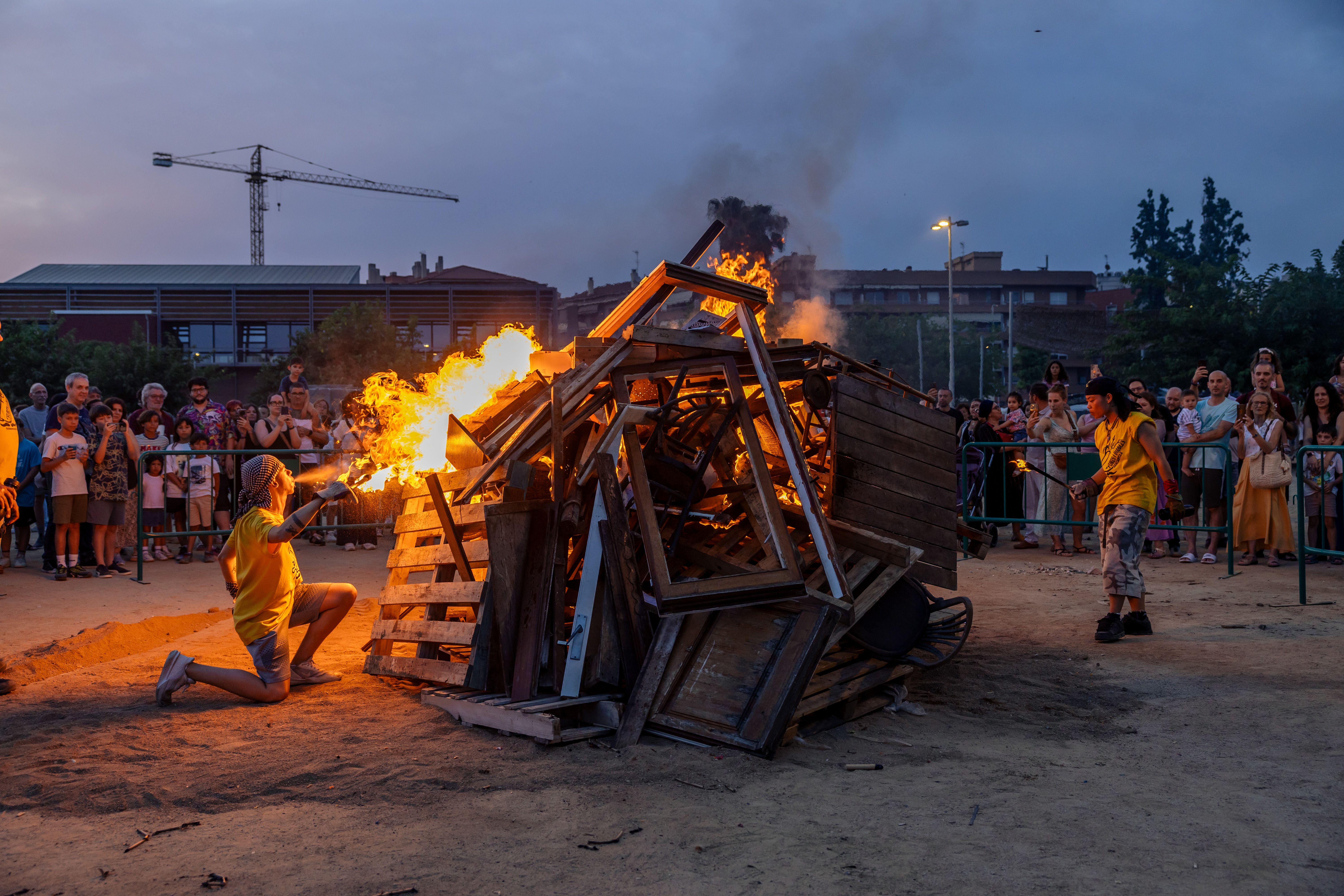 Instants de la revetlla de Sant Joan a Cerdanyola, des de l'arribada de la flama del Canigó fins a l'encesa de la foguera al parc Xarau. FOTO: Arnau Padilla.