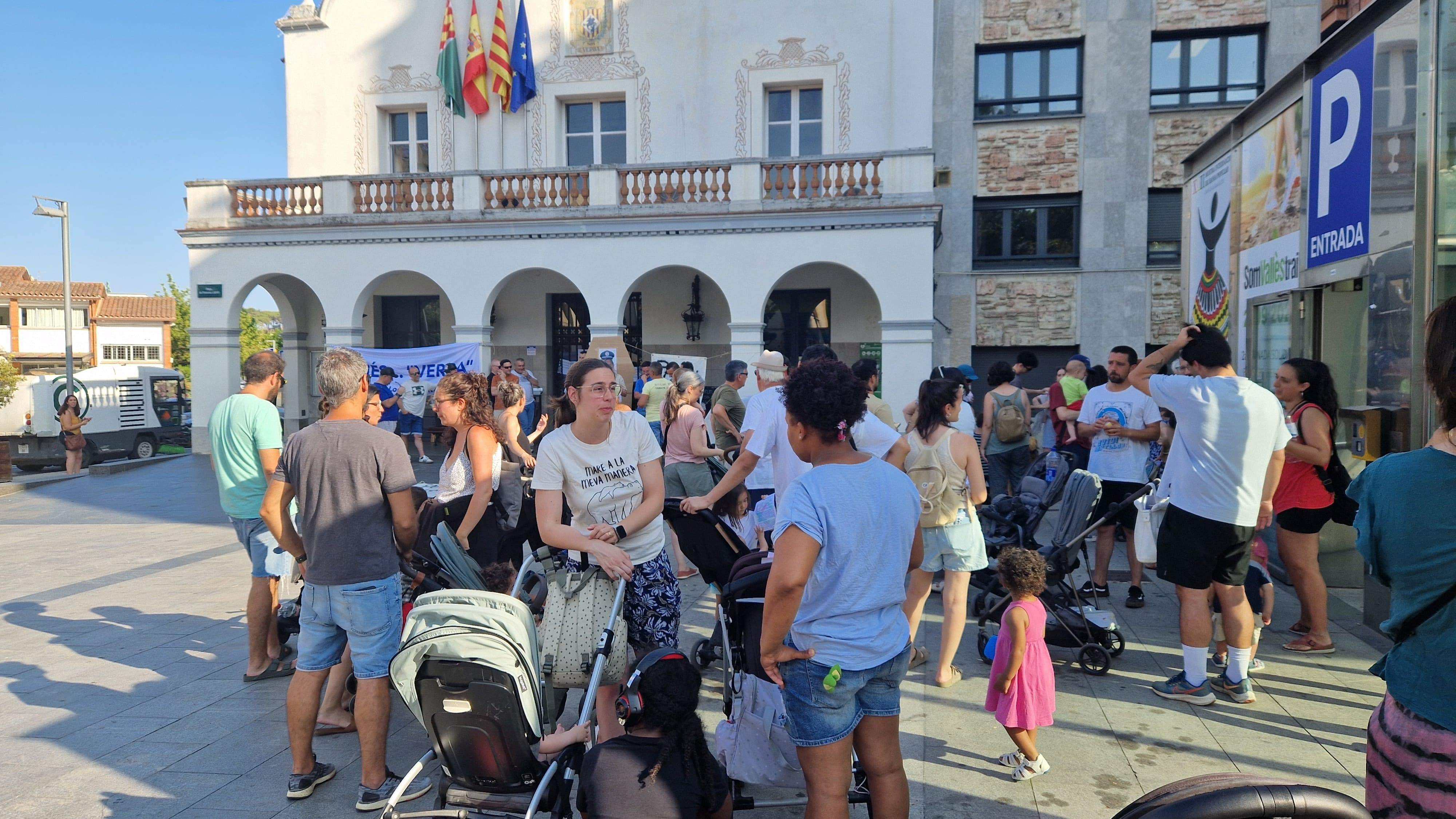 Concentració dijous de les famílies sense places d'infants. Al fons manifestació de la Policia Local. 
