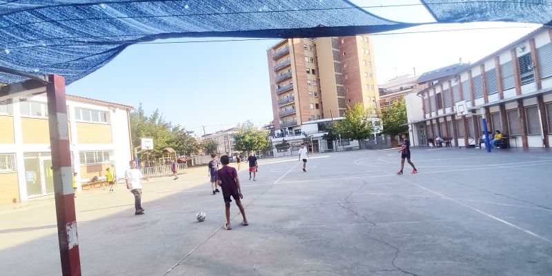Un grup de joves i infants juguen a futbol a l'escola de Sant Martí, durant els patis oberts. FOTO: TOT Un grup de joves i infants juguen a futbol a l'escola de Sant Martí, durant els patis oberts. FOTO: TOT