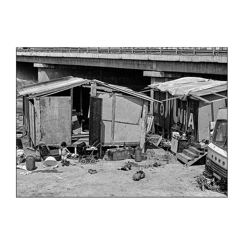  Una llar feta a mà. Construccions improvisades amb fustes, lones i retalls publicitaris. Les joguines escampades al terra contrasten amb la precarietat extrema de l’habitatge. Any: 1982 – Fotografia de Vicenç Semper