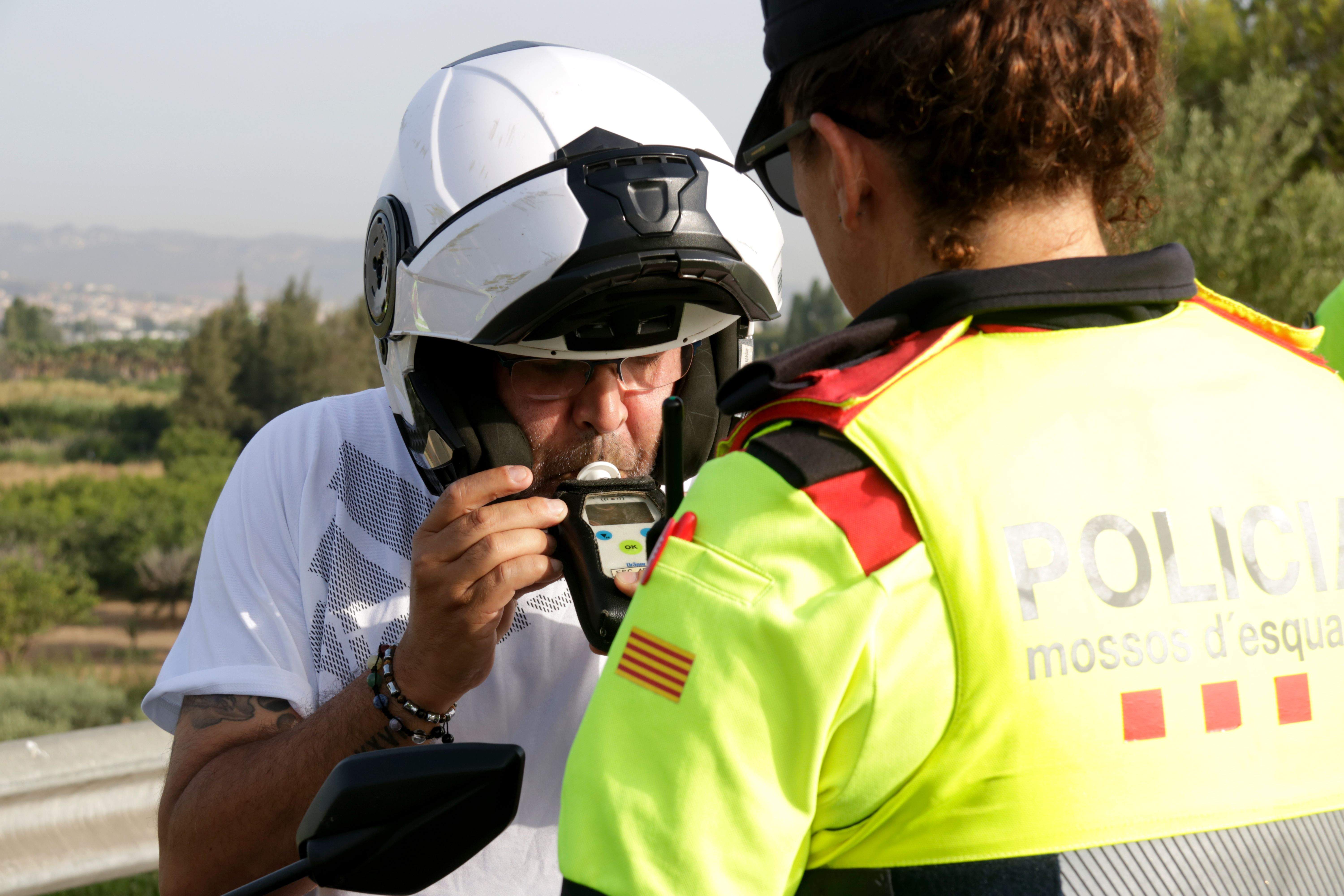 Una agent dels Mossos d'Esquadra sotmet a la prova d'alcoholèmia un motorista.   FOTO: Albert Hernàndez (ACN/arxiu)
