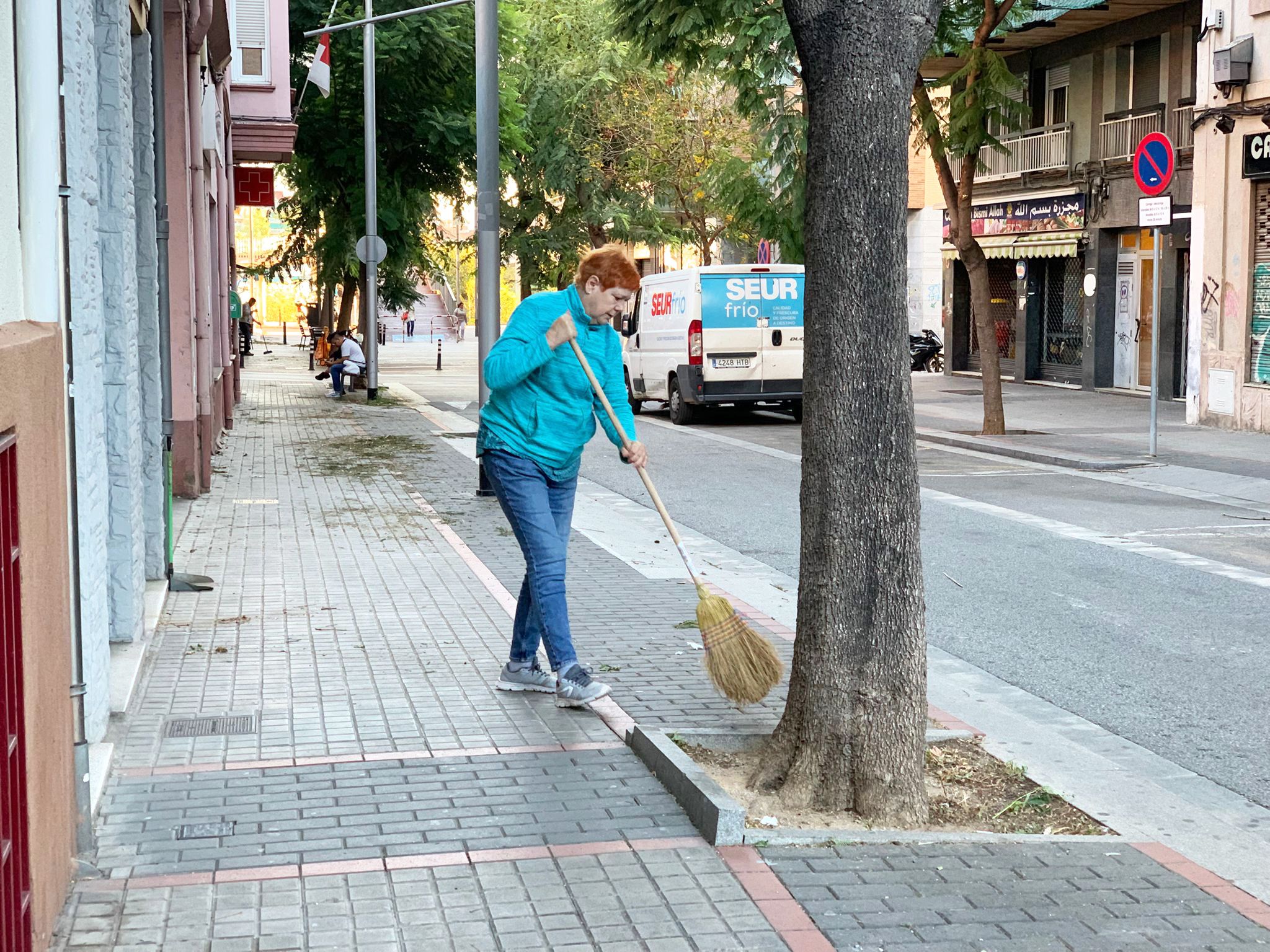Una veïna escombra a l’avinguda de la Creu Roja. Foto: Judit Josa.