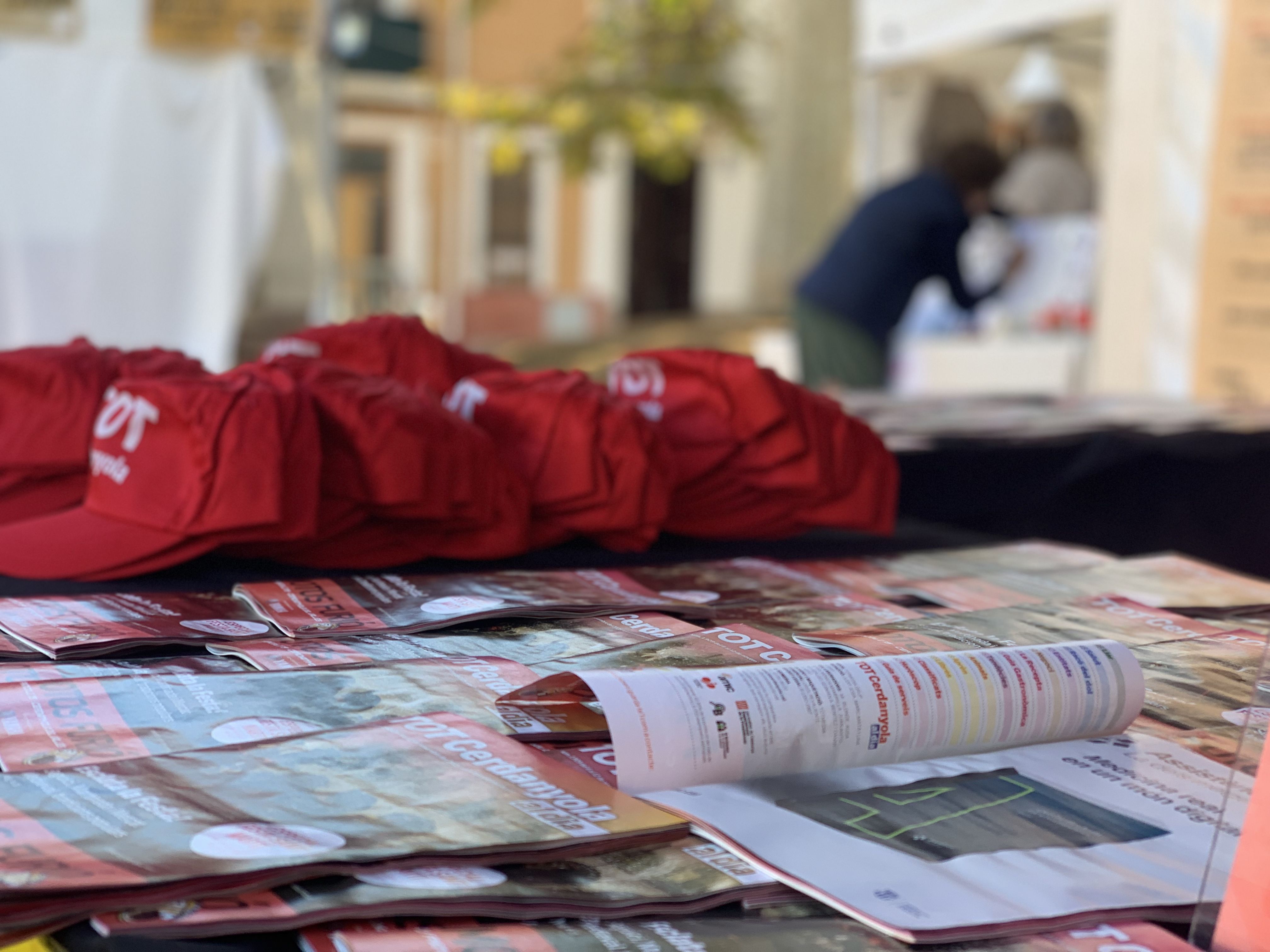 Detall del material repartit a la parada del TOT: revistes, gorres i globus per als visitants.