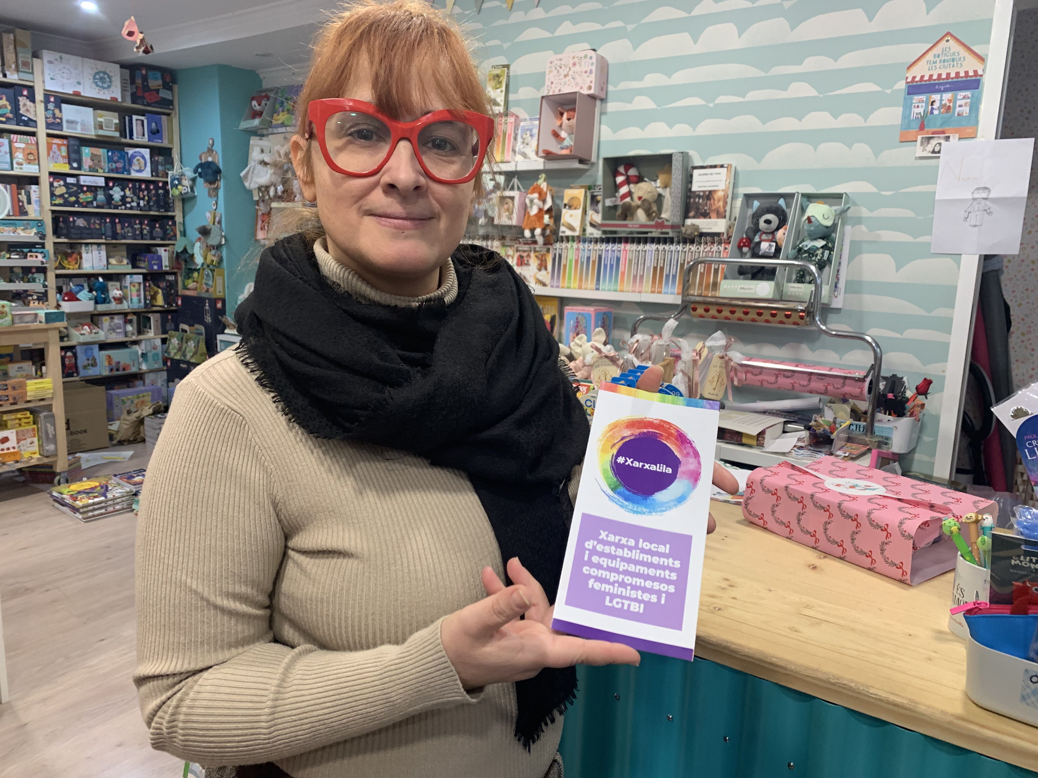 La llibretera Núria Nájera, de la Llibreria Lilliput, mostrant el tríptic informatiu de la Xarxa Lila. FOTO: Judit Josa