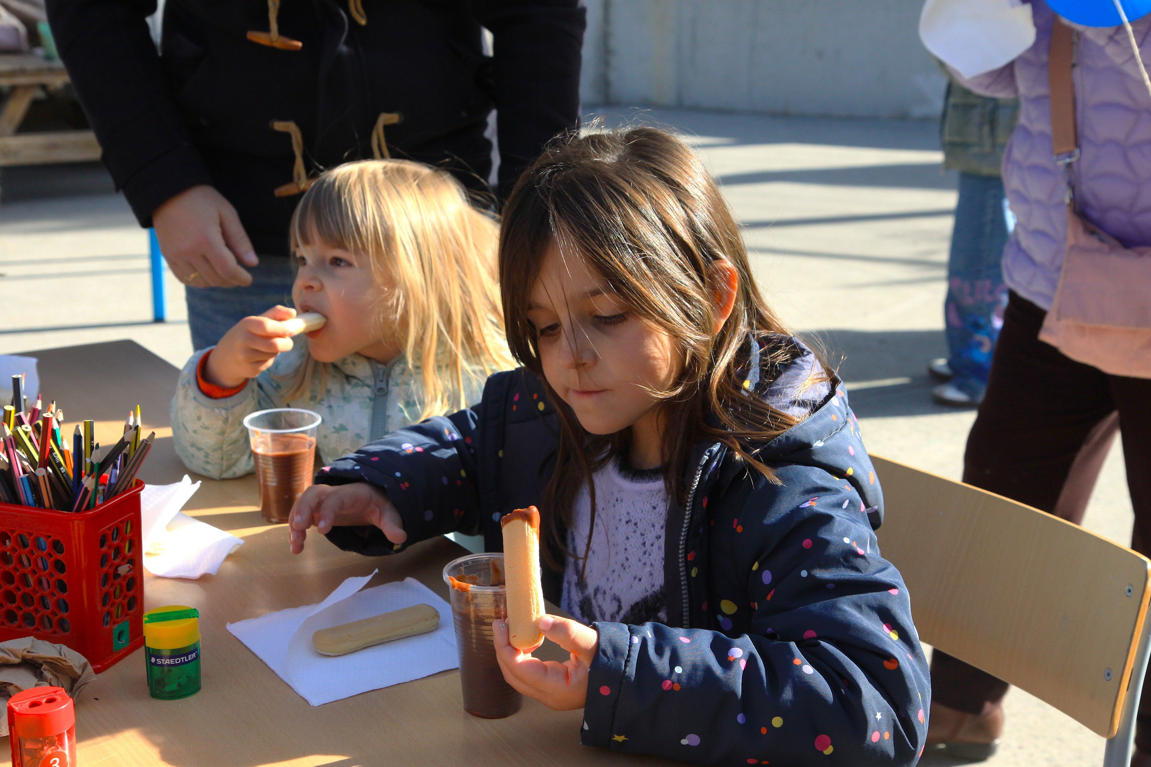 Dues alumnes gaudint de la xocolata amb melindros. 