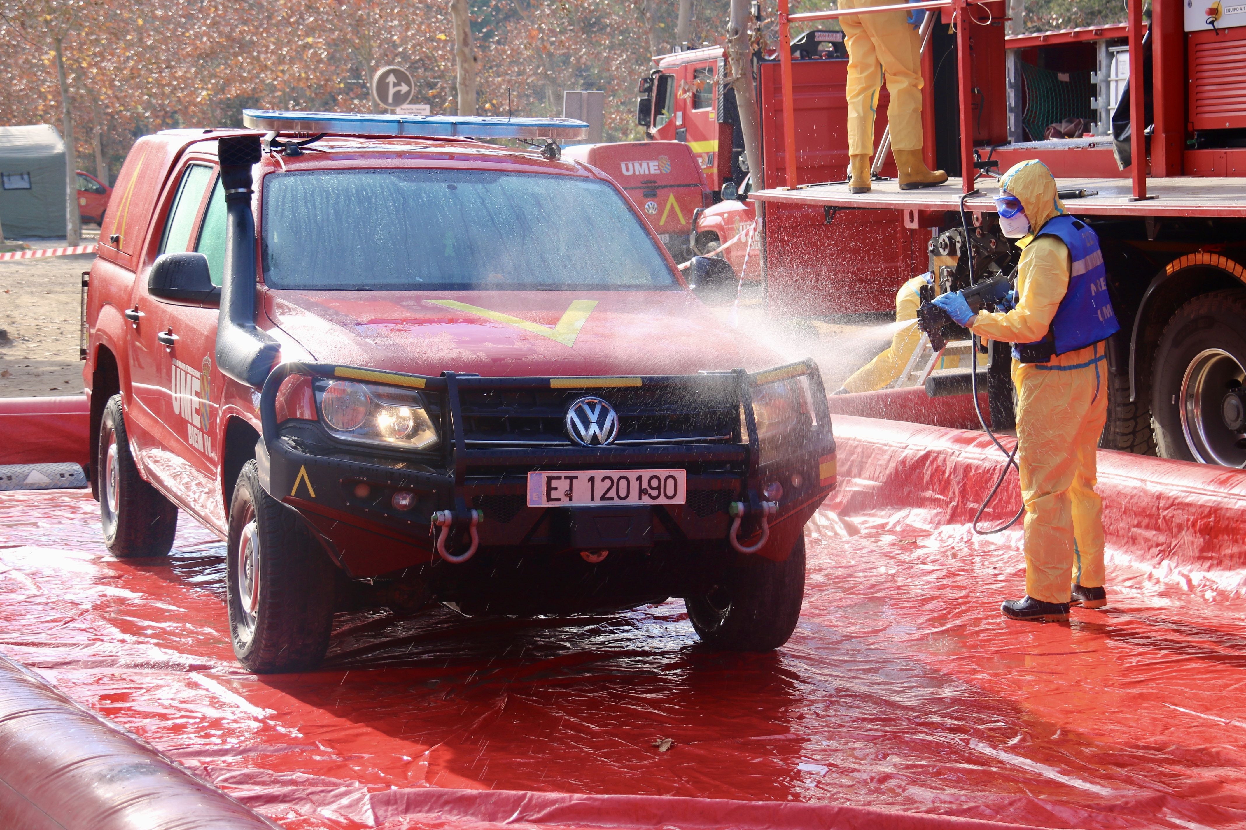 Un membre de l'UME desinfectant un vehicle a l'estació de descontaminació de Can Coll, a Cerdanyola del Vallès. FOTO: Albert Segura (ACN)