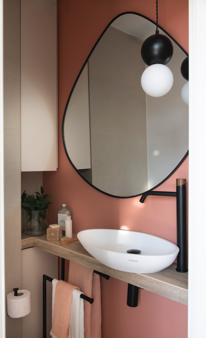 El bany de cortesia amb tons roses i negres FOTO: 