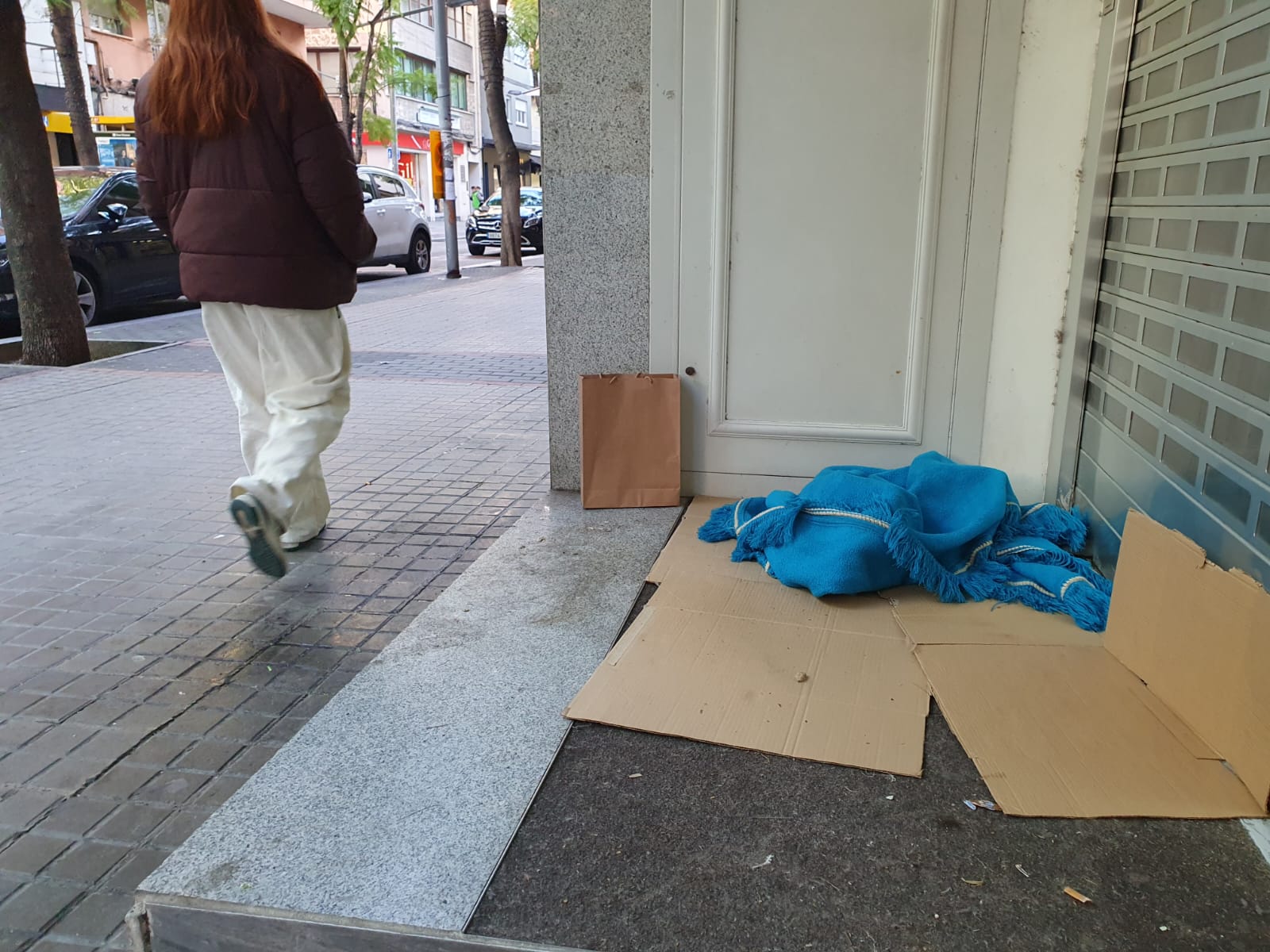 El replà d’un local tancat, amb mantes i cartrons a terra, a l’avinguda de Catalunya. Aquests elements indiquen que algú hi ha passat la nit. FOTO: Judit Josa