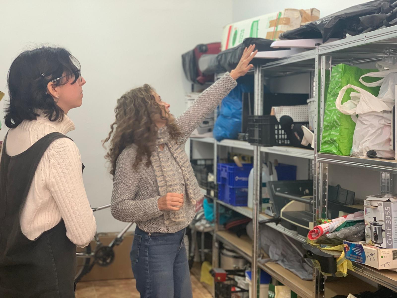 Noemí Morillas i Andrea González, de Populus Labora i la Gresca, mostren el magatzem de la Cosateca, una 'biblioteca' per deixar en prèstec utensilis i objectes. FOTO: Judit Josa