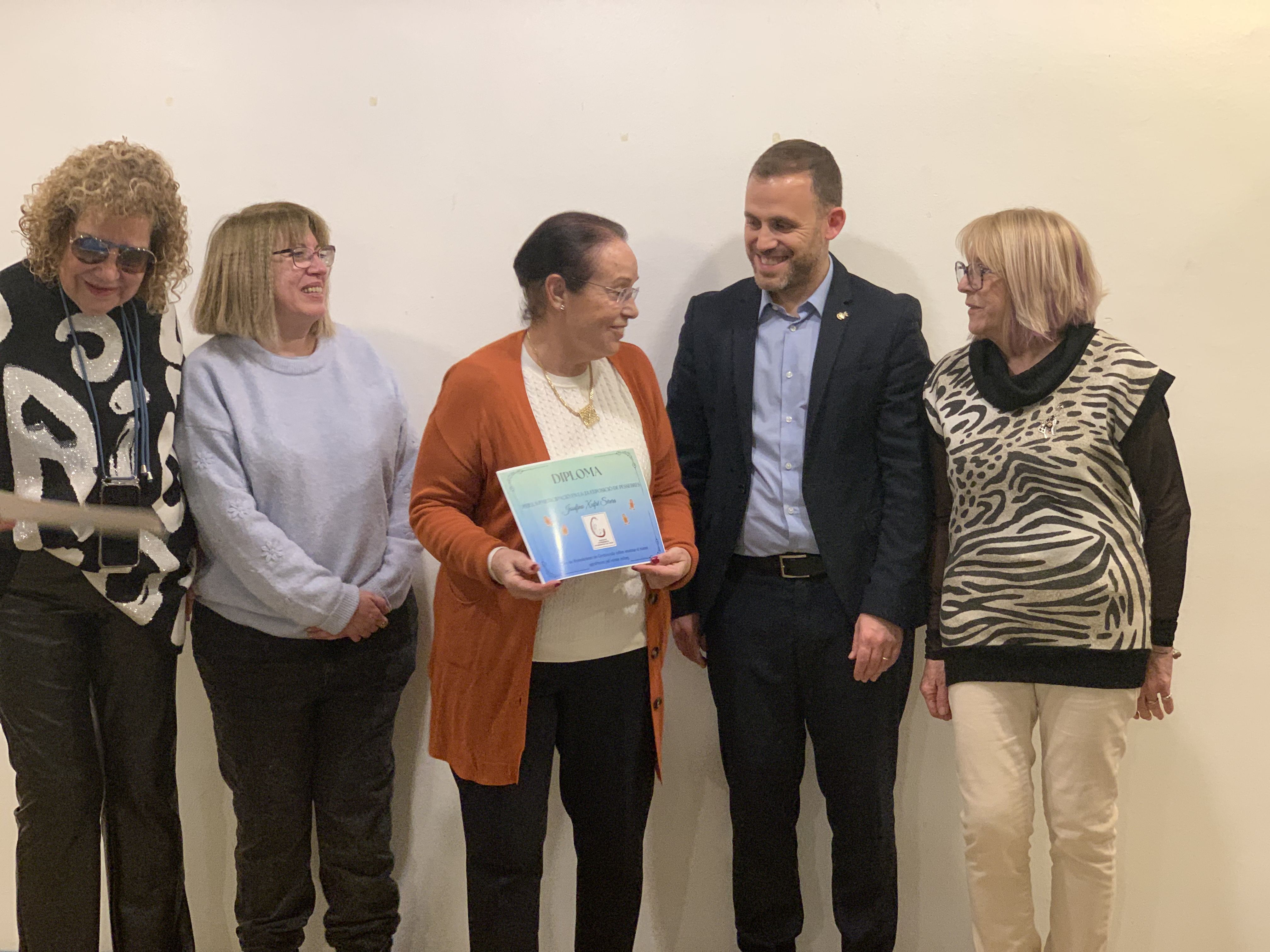 Les creadores i creadors dels pessebres exposats a l’Ateneu reben els diplomes de reconeixement durant l’acte de cloenda.