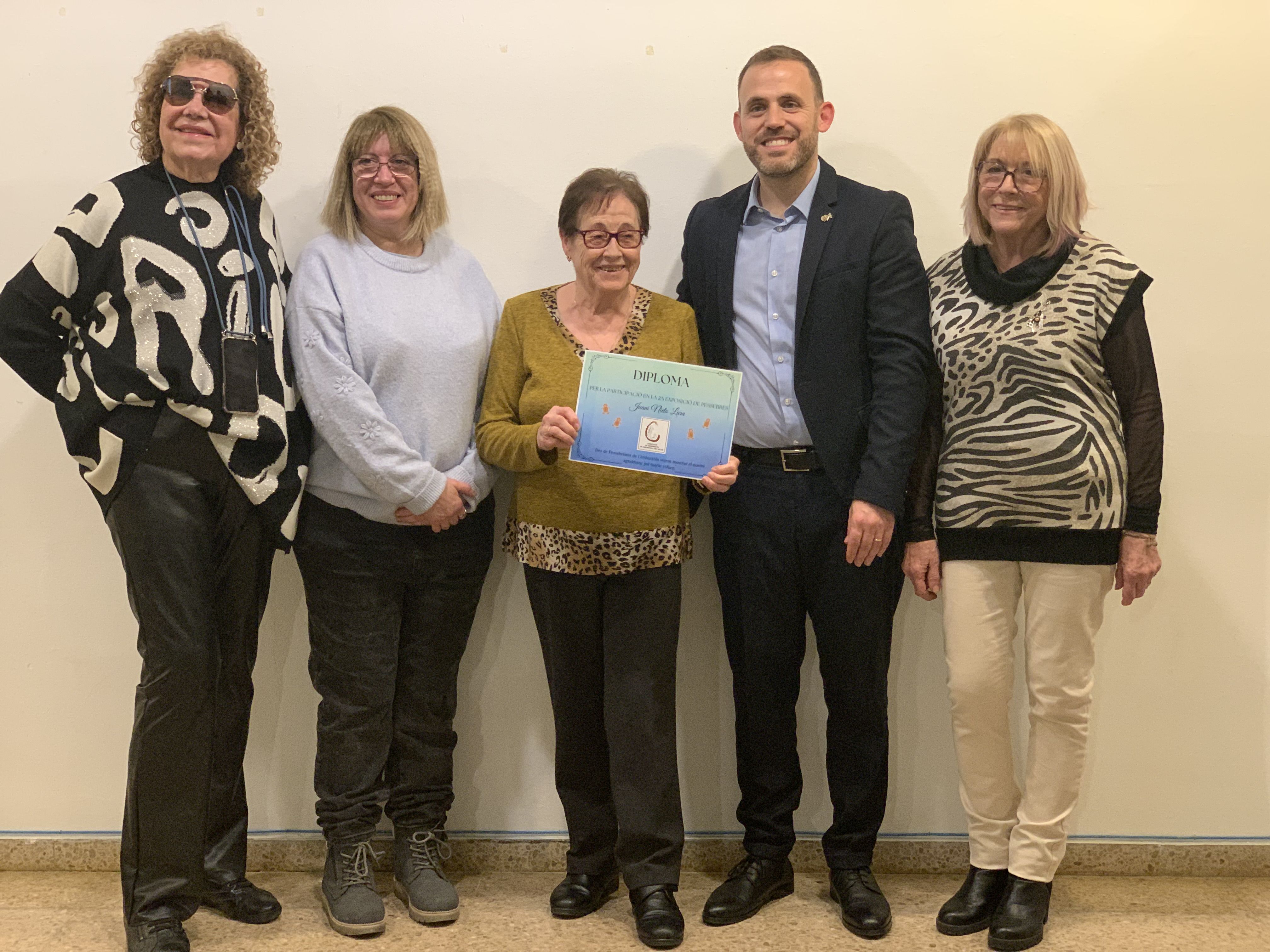 Les creadores i creadors dels pessebres exposats a l’Ateneu reben els diplomes de reconeixement durant l’acte de cloenda.