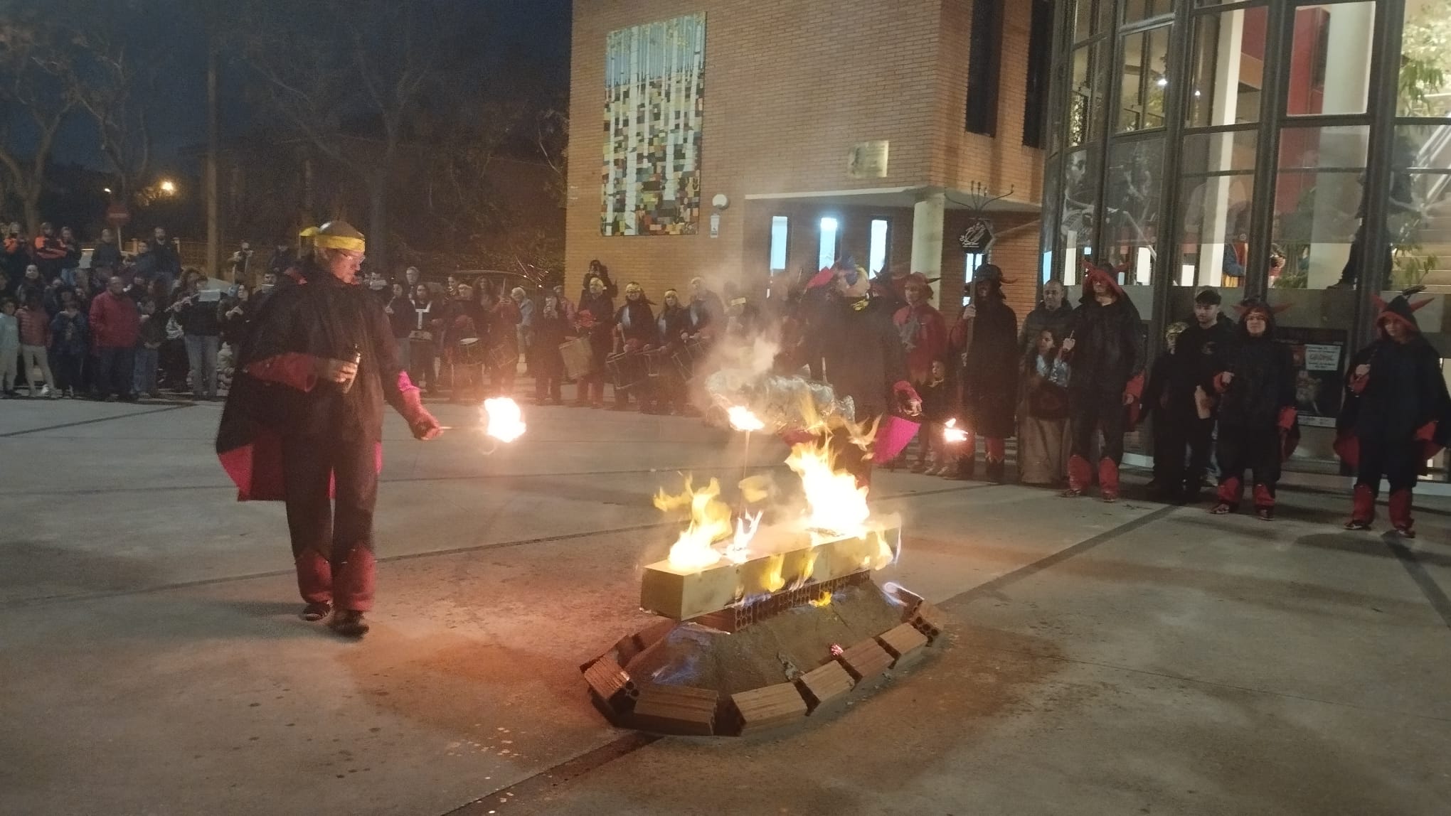 Un dels diables encén el taüt davant la mirada del públic. FOTOS: Sergio Torres