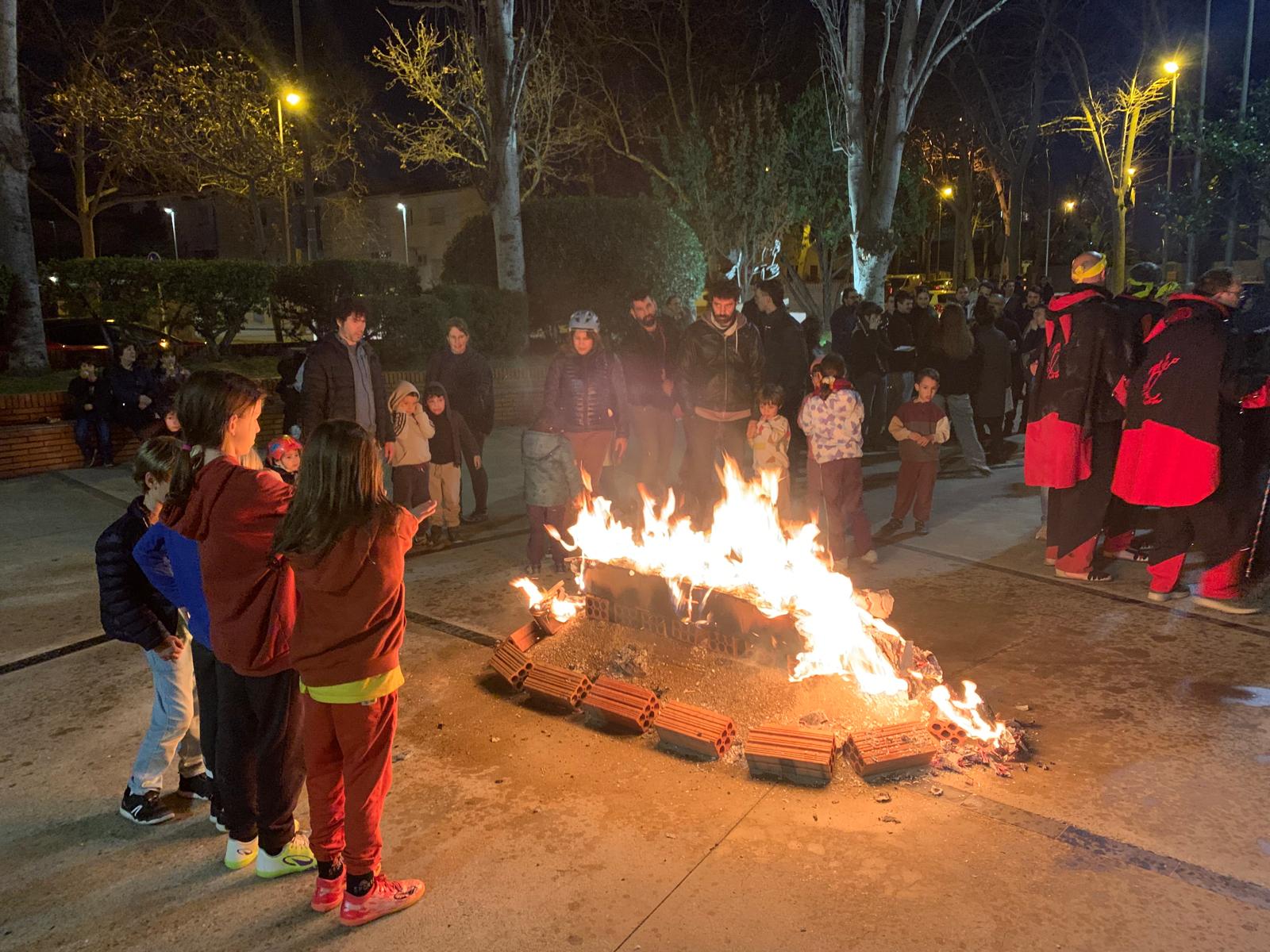 Infants i famílies observen el taüt en flames en el moment final de l’Enterrament de la Sardina. FOTOS: Judit Josa