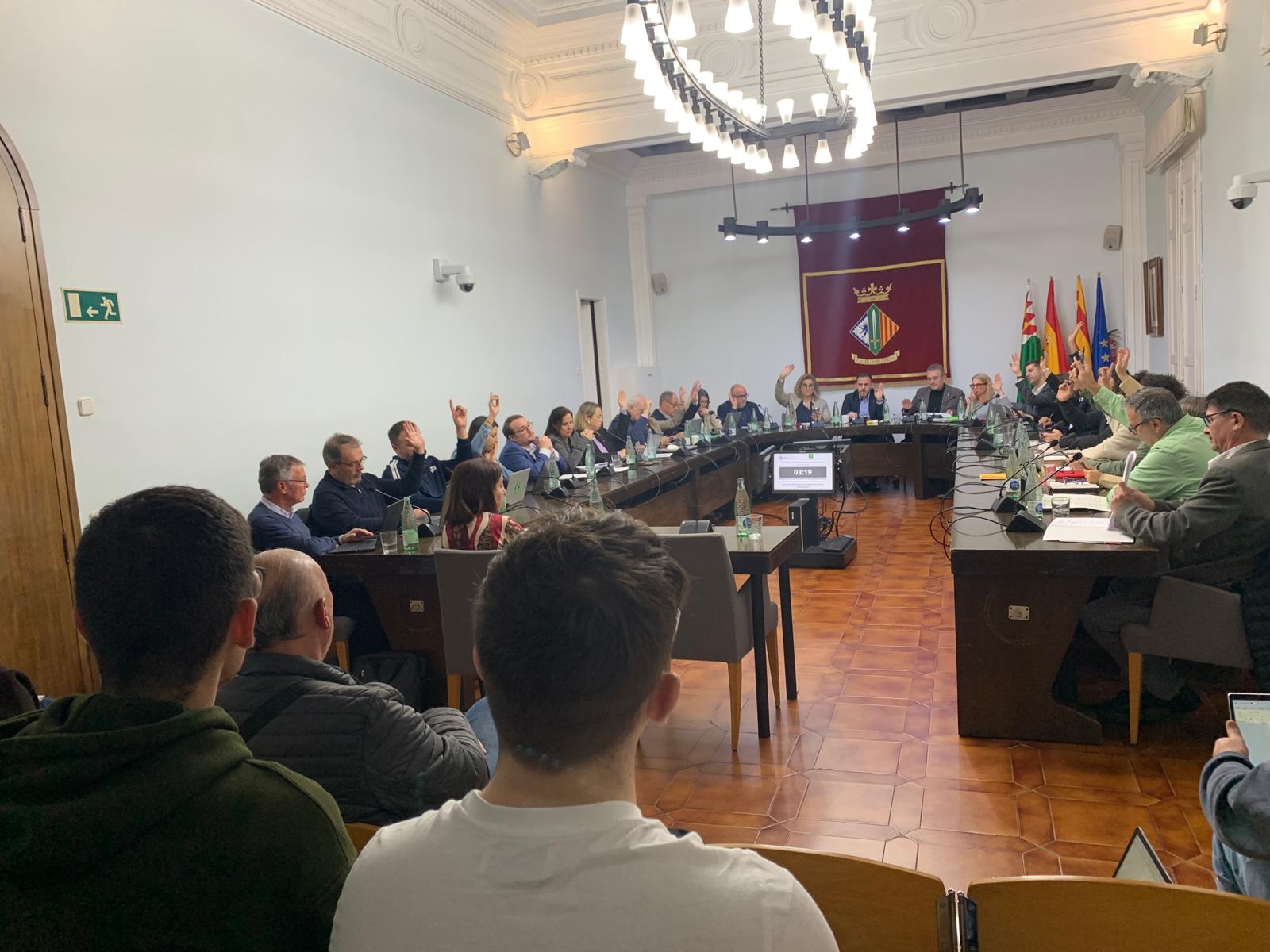 Votació a mà alçada d'una de les propostes del plenari de febrer, amb presència del president de l'EMD i entre el públic, estudiants universitaris de sociologia seguint la sessió. FOTO: Judit Josa