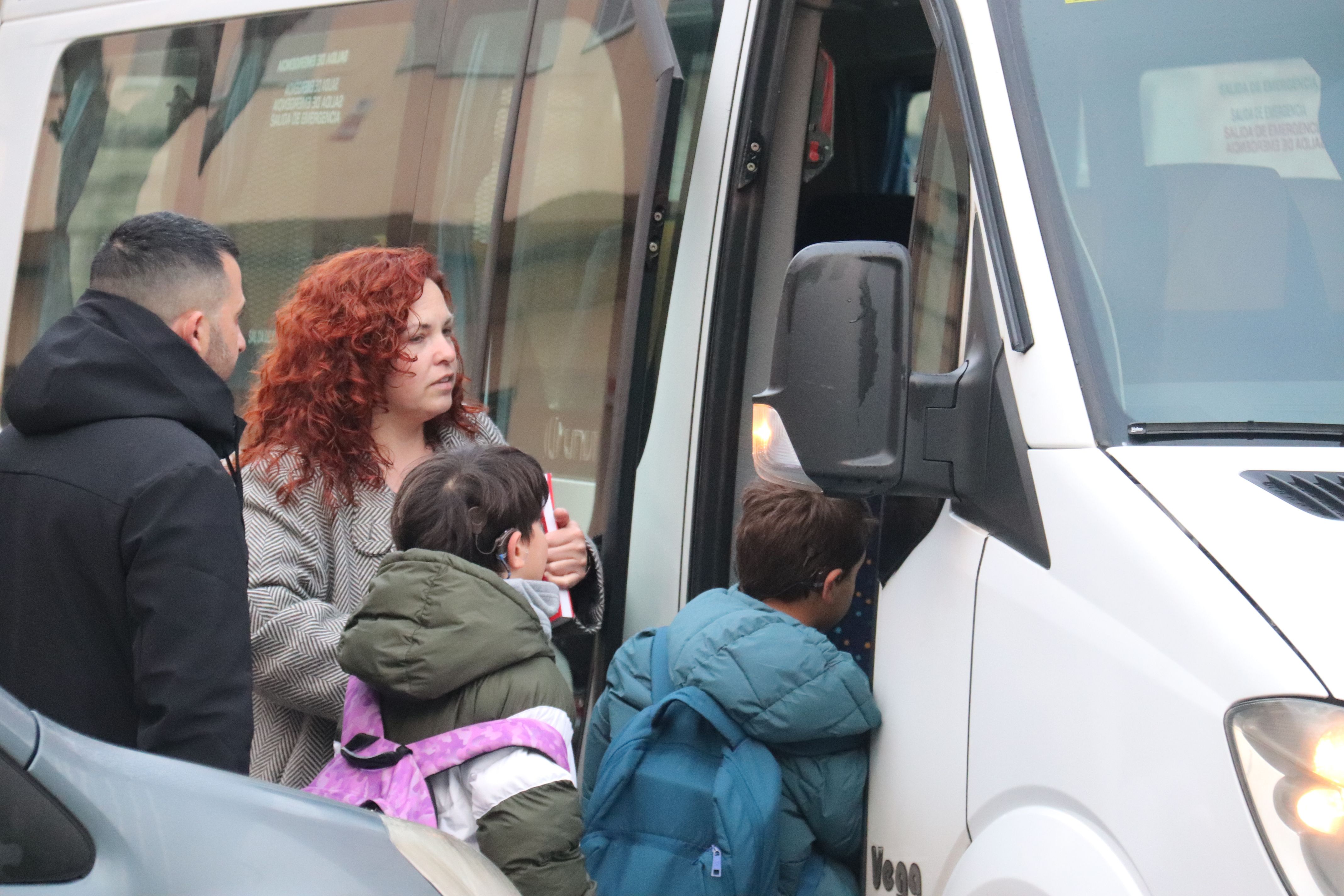 Dos infants s'acomiaden dels seus pares i entren al servei de bus escolar per anar cap a l'Escola Bellaterra des de Montcada i Reixac. FOTO: Miquel Codolar