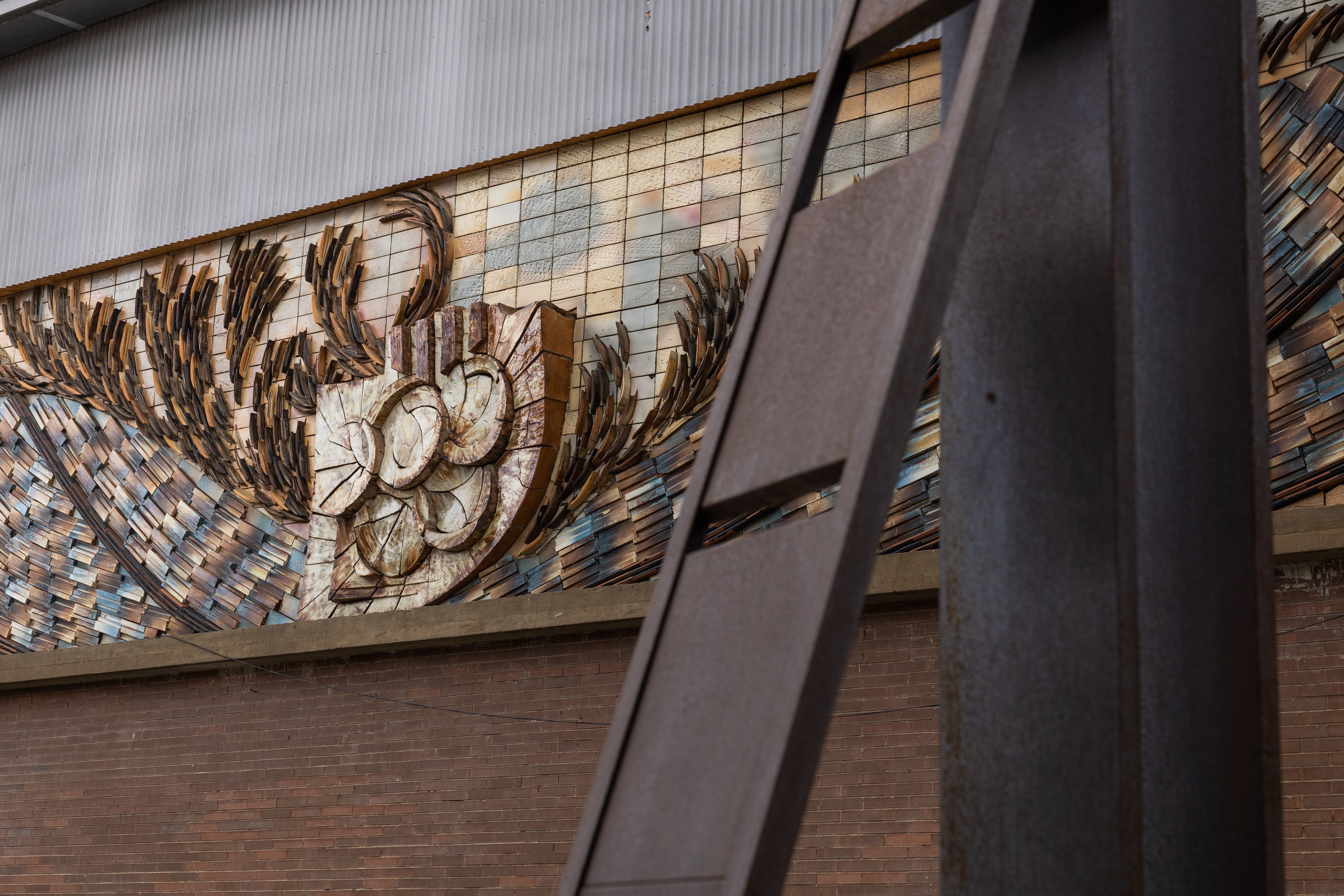 El mural ceràmic del pavelló de Can Xarau dialoga amb l'escultura Punt de partida,  dues obres d'Elisa Arimany. FOTO: Arnau Padilla.