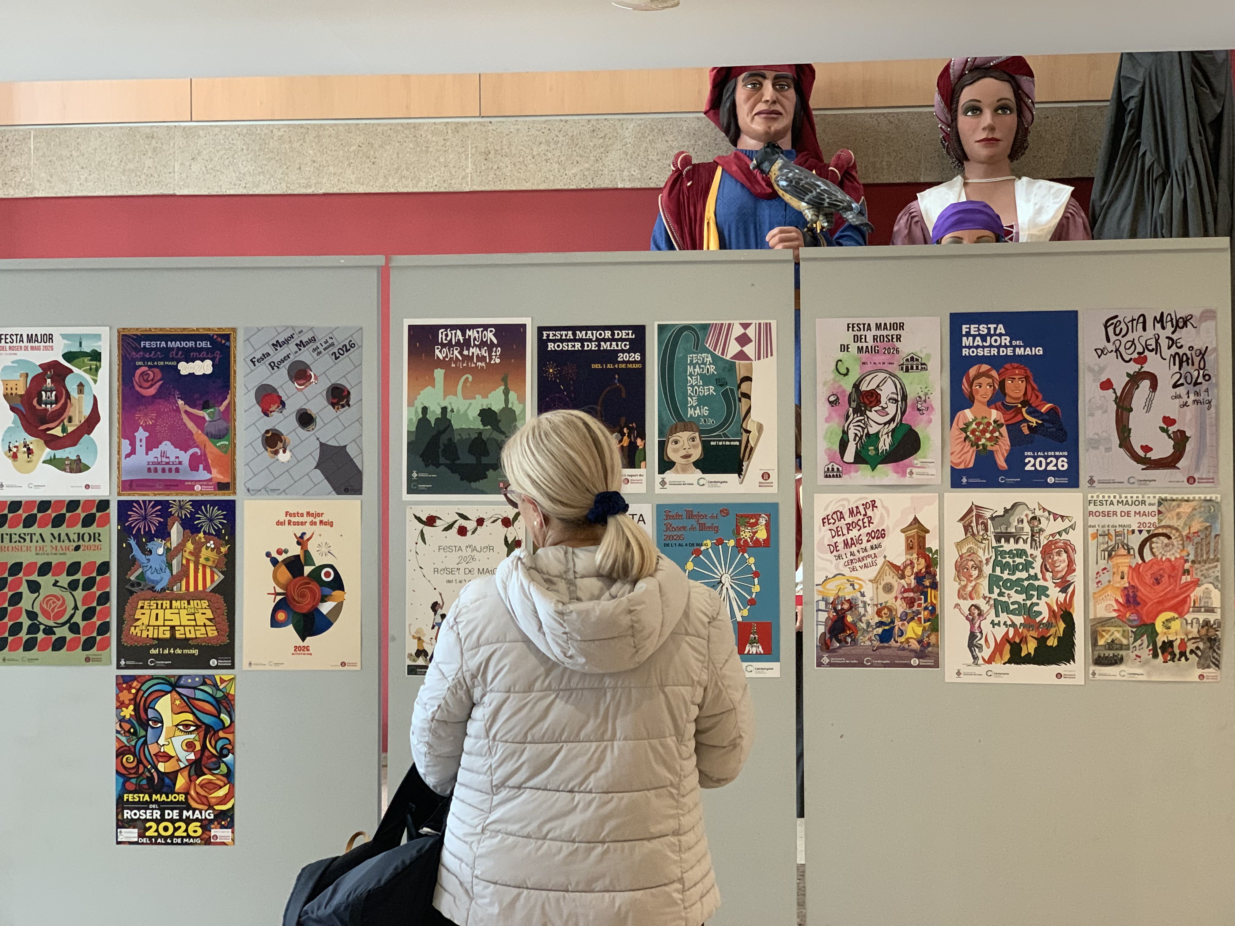 Una dona observa els plafons de la categoria adulta al vestíbul de l’Ateneu, sota la mirada dels gegants de Cerdanyola, Bernat i Victòria. FOTO: Judit Josa