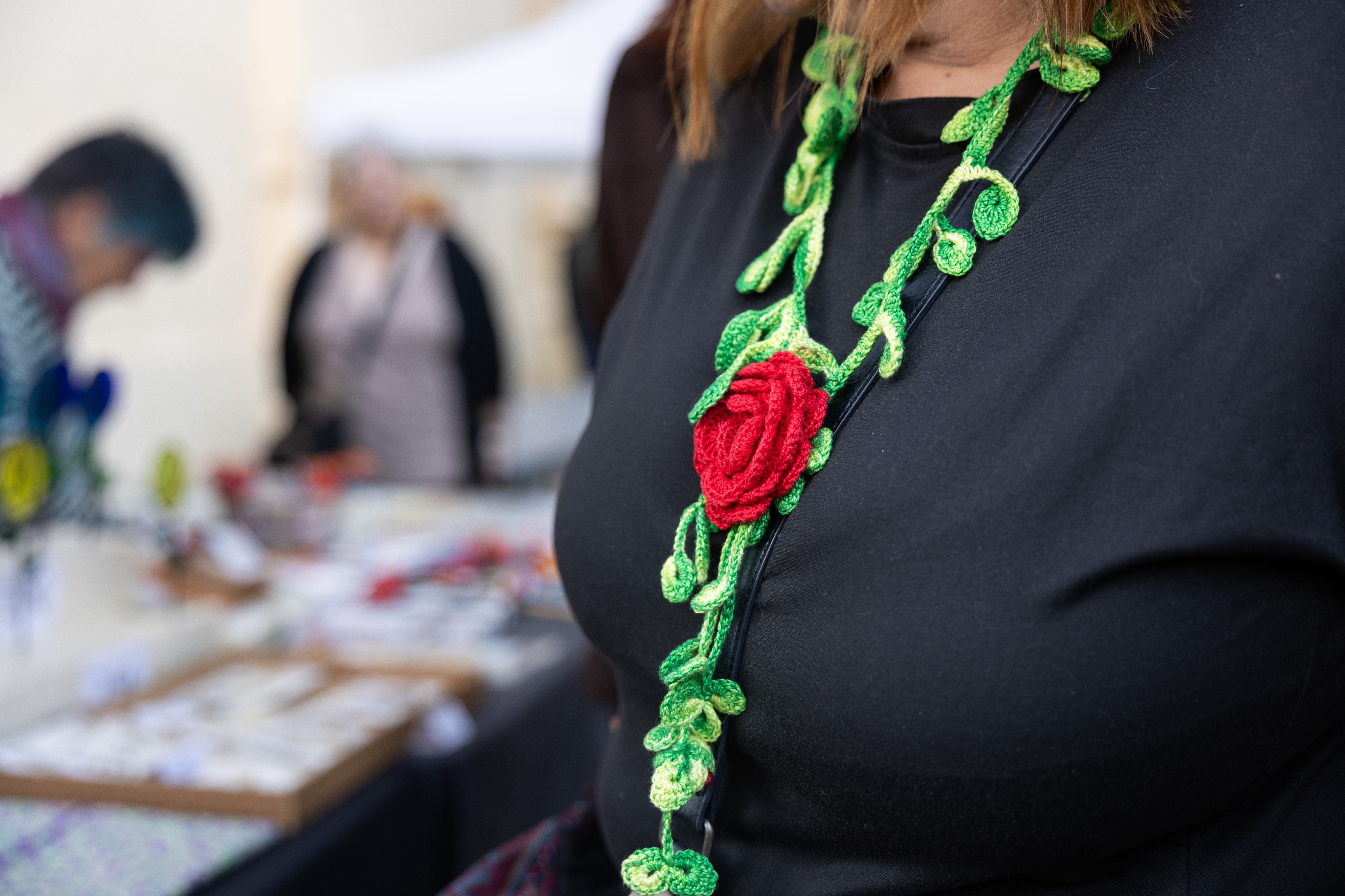 Penjoll amb una rosa de ganxet, una de les múltiples creacions imaginatives de la plaça, utilitzat per identificar els organitzadors. FOTO Arnau Padilla