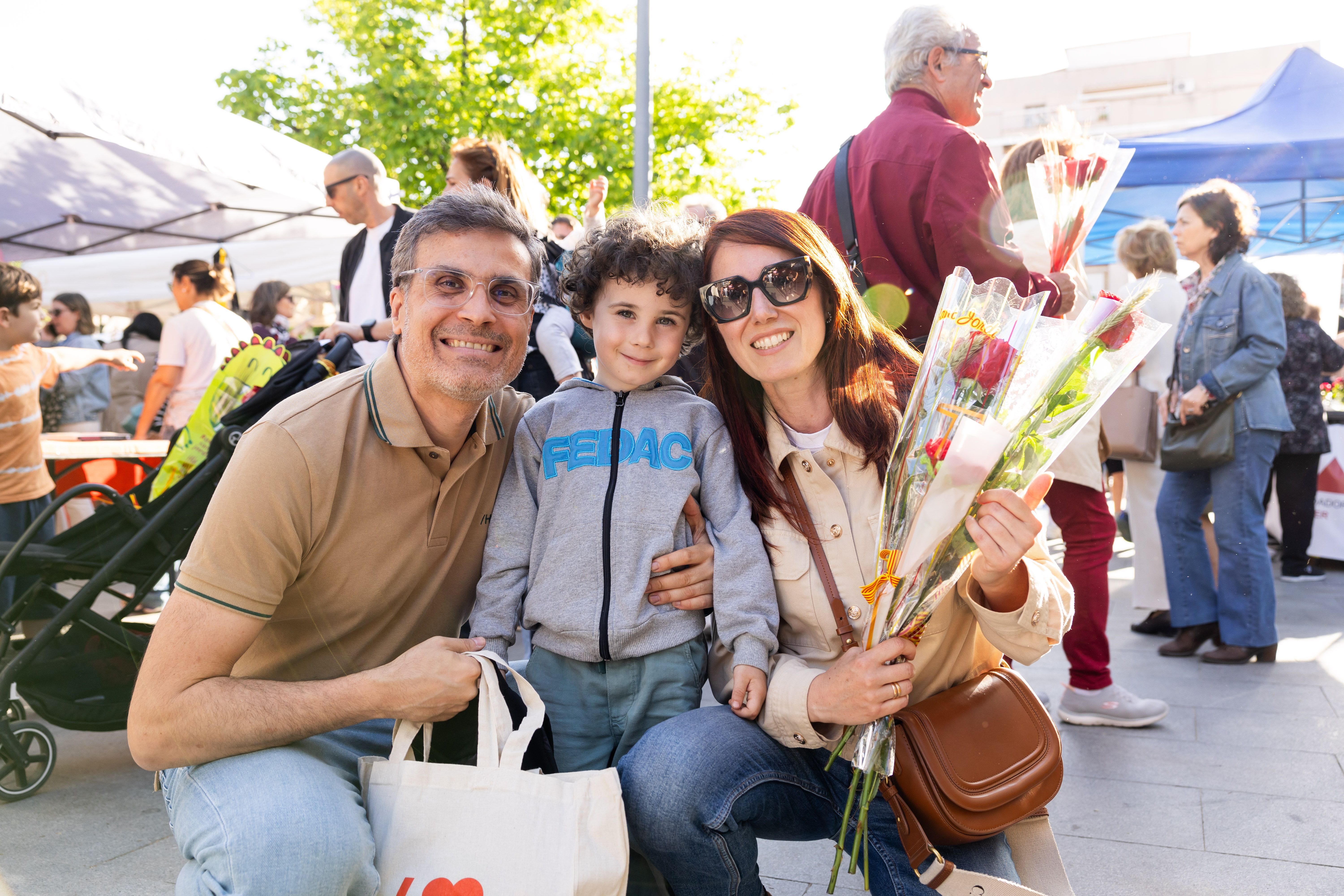 Una família, pare, mare i fill, posa amb una rosa a la plaça de l’Abat Oliba durant la diada de Sant Jordi. FOTO Arnau Padilla