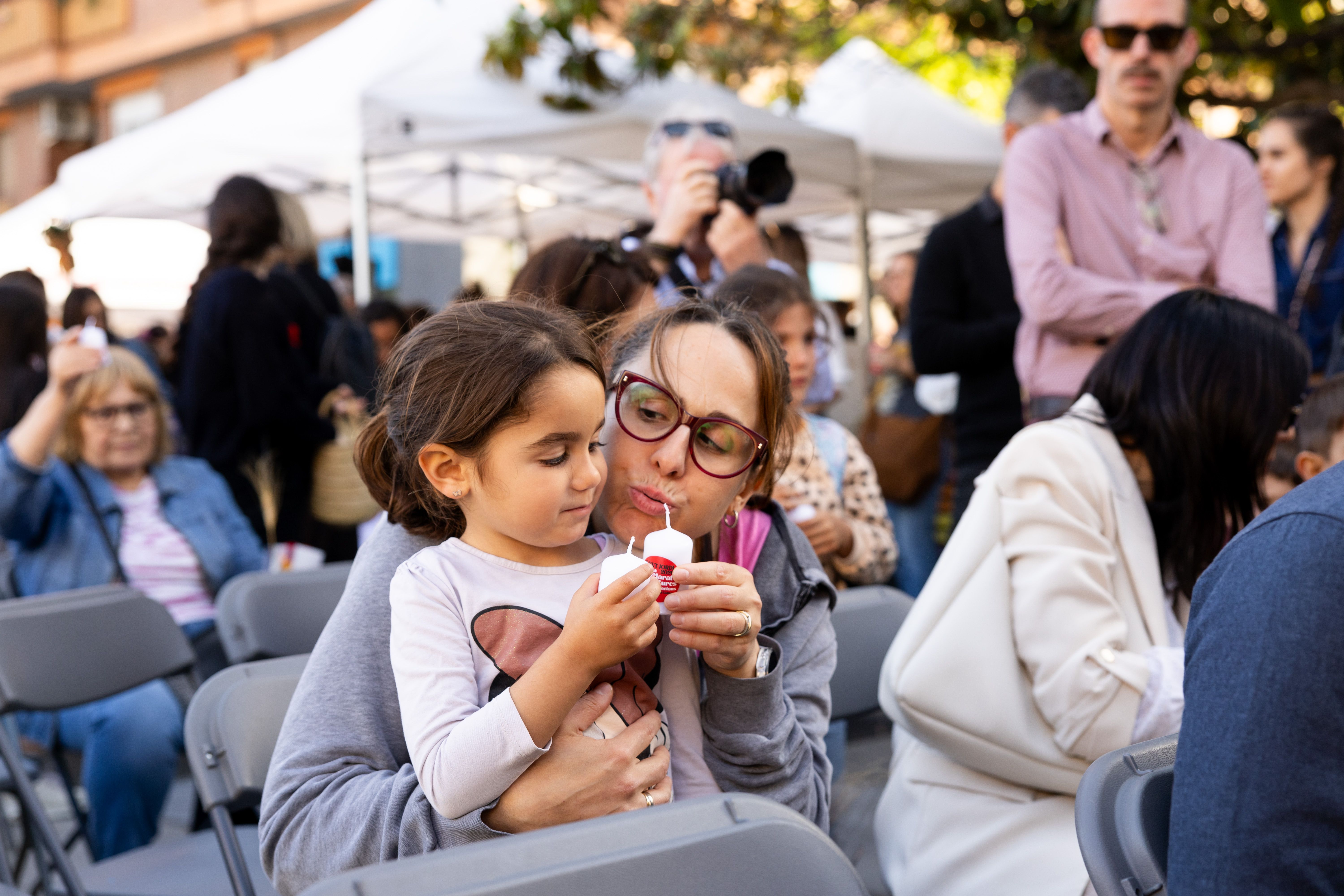 Una mare i una nena bufen les espelmes en la celebració col·lectiva dels 25 anys de la Marató de Lectura a la plaça de l’Abat Oliba. FOTO Arnau Padilla