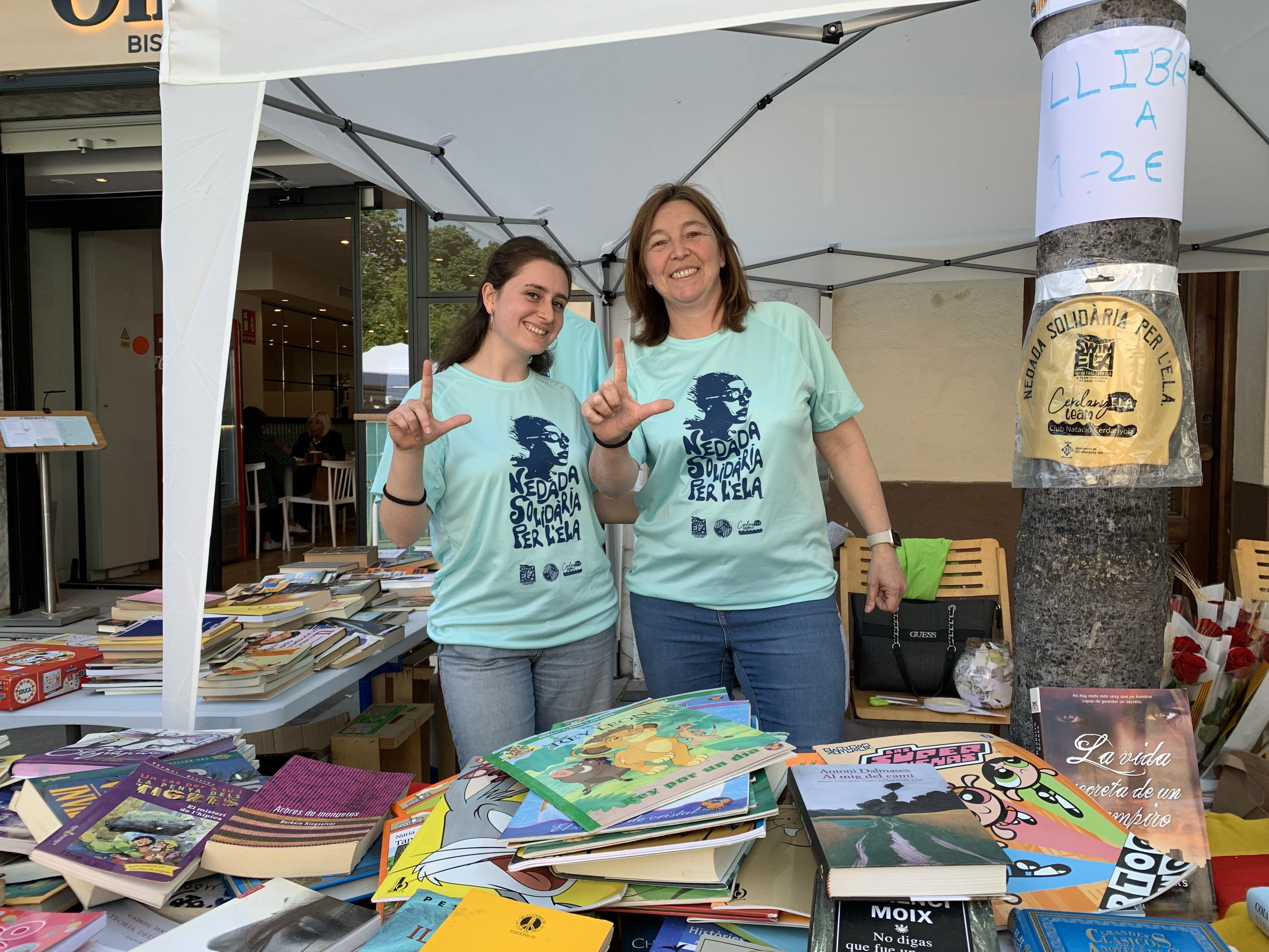 Responsables del Club de Natació fan el gest per l’ELA a la parada de Sant Jordi, on recollien fons per a la nedada solidària de diumenge a Xarau. FOTO: Judit Josa