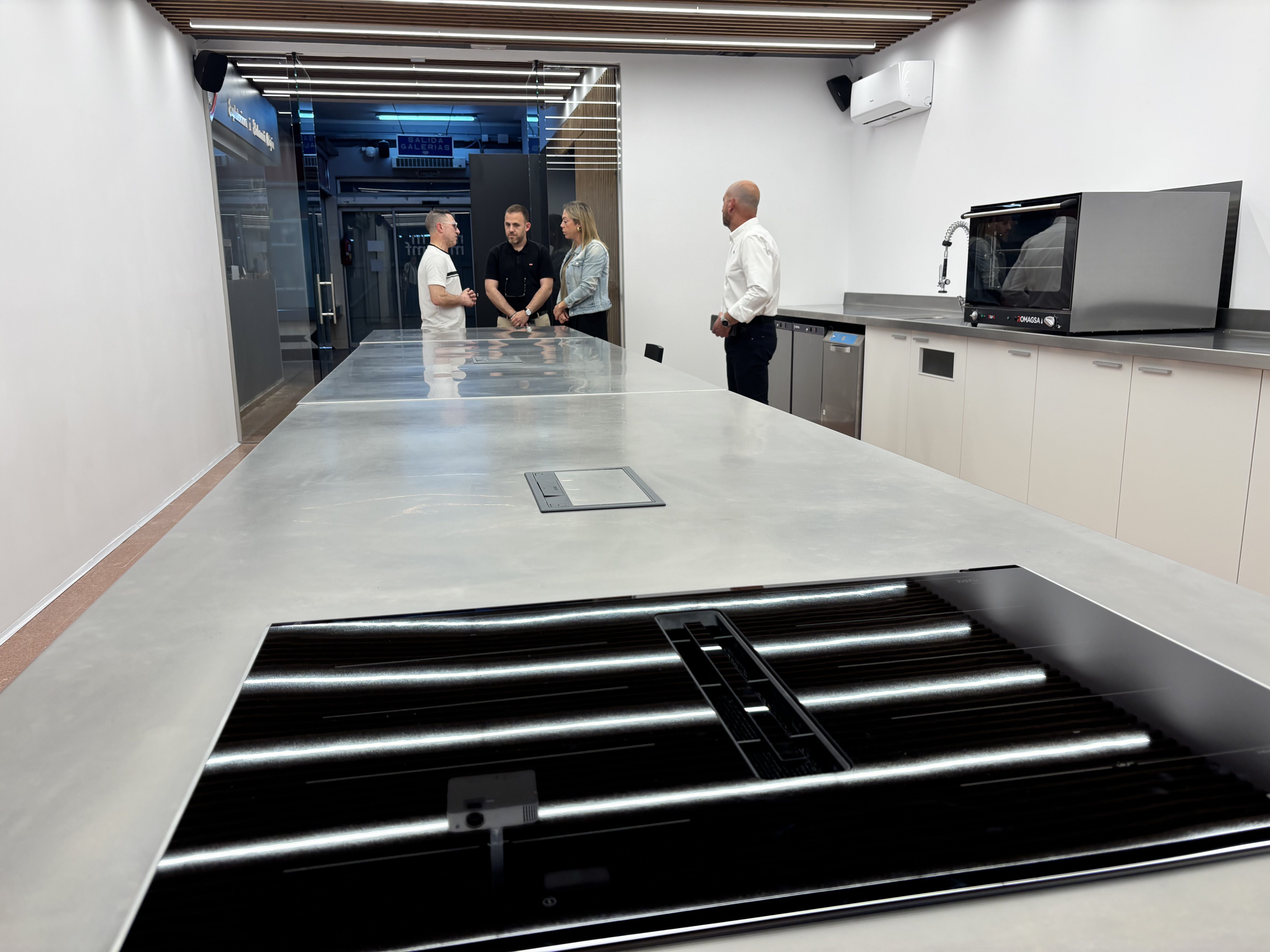 El president dels comerciants, Julià Puig; l’alcalde, Carlos Cordón; i la regidora, Cristina Padilla, a la nova aula de cuina del Mercat de les Fontetes. FOTO: Ajuntament