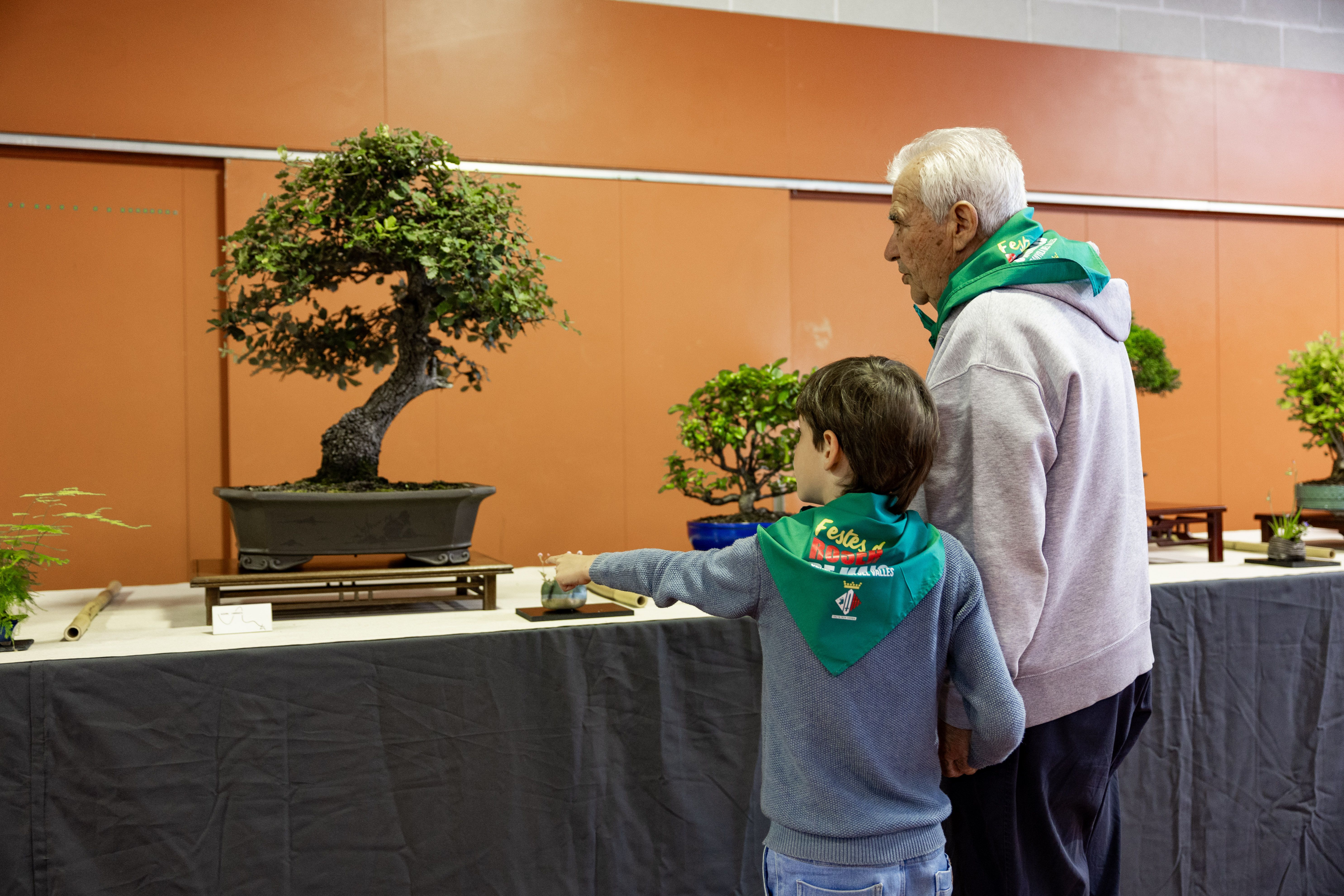 Un avi i un nen visiten l’exposició amb el mocador del Roser de Maig. FOTO: Arnau Padilla