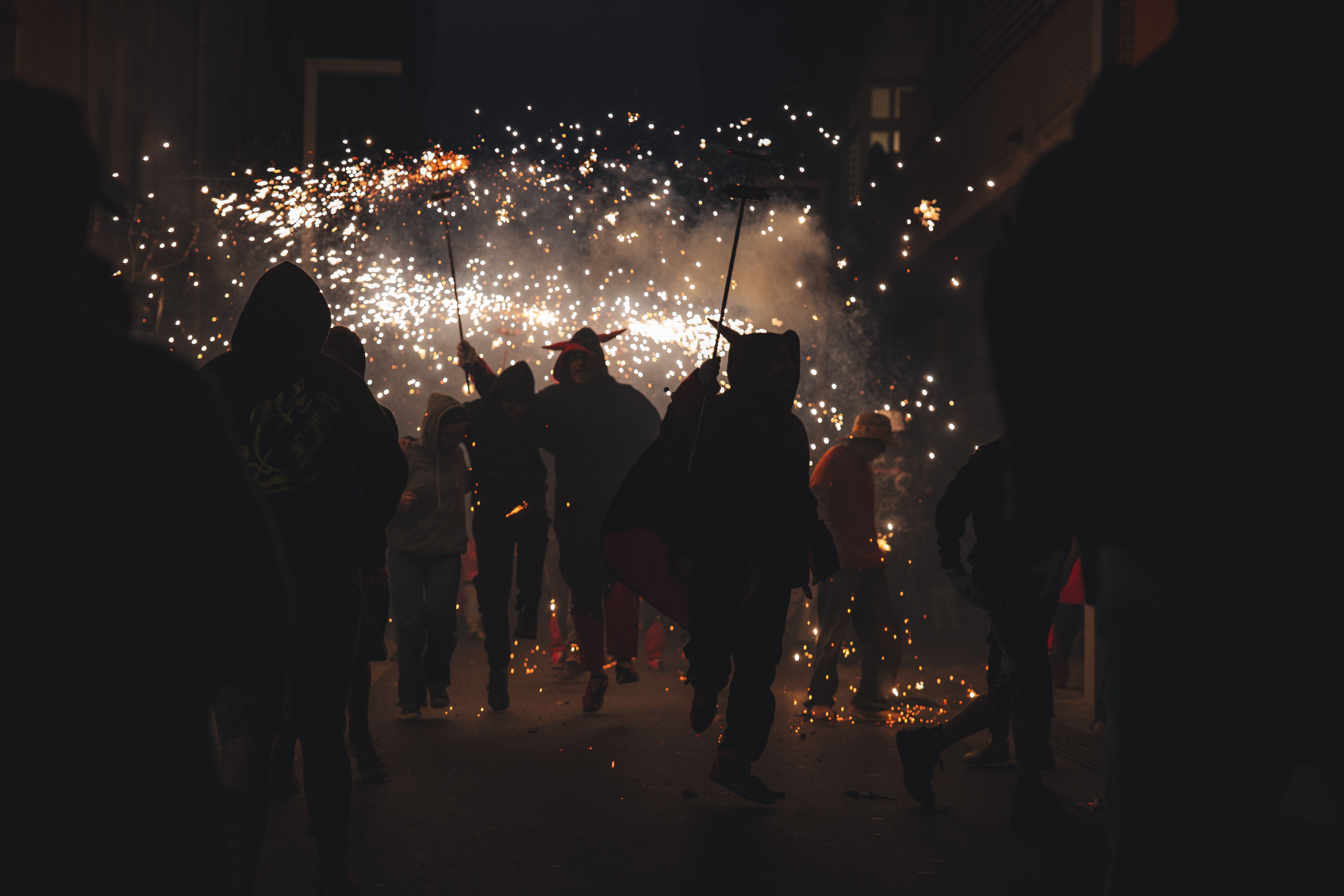Els diables mantenen el ritme amb els ceptrots encesos mentre el carrer es transforma en un túnel de foc. FOTOS: Arnau Padilla