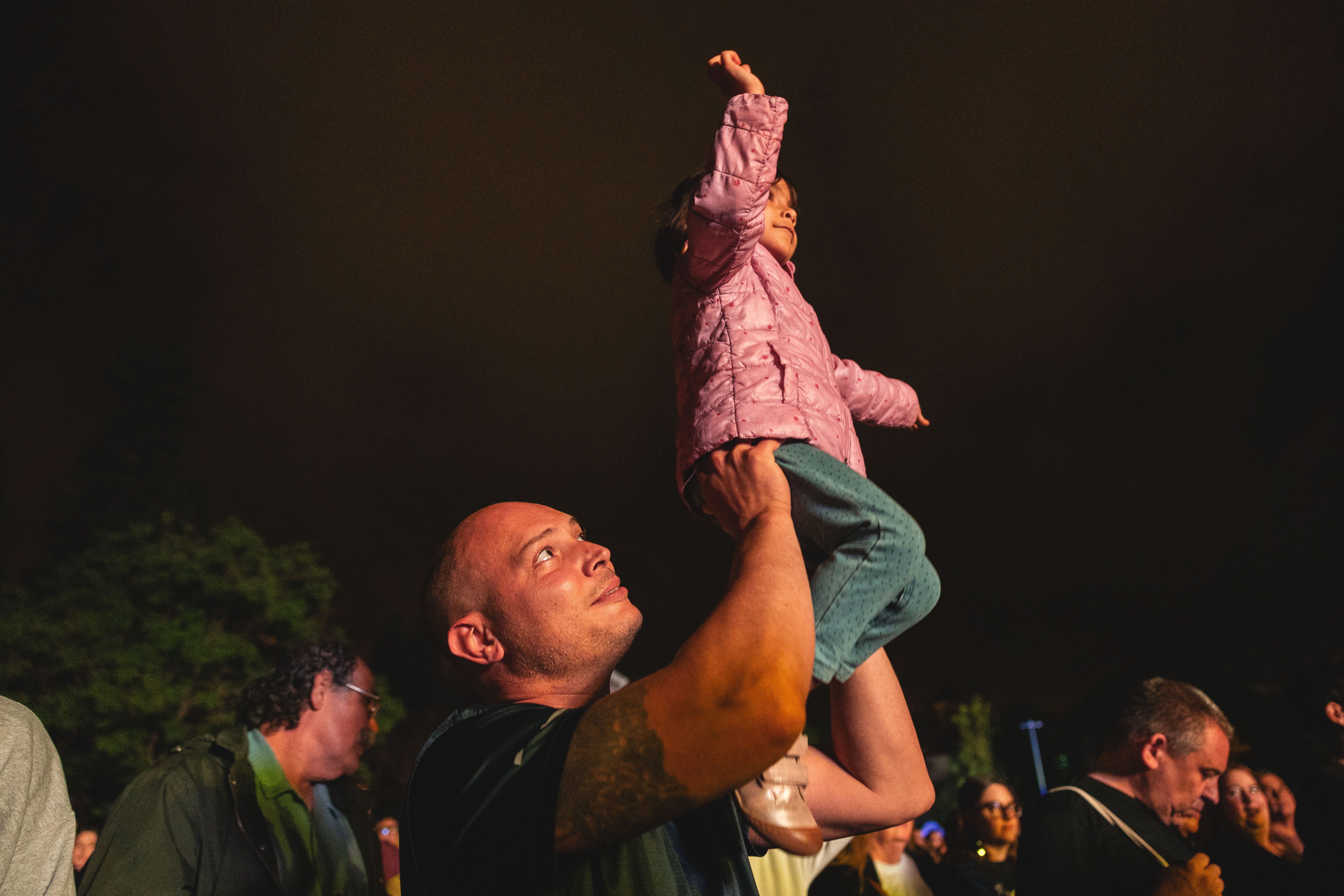 Una nena segueix el concert en braços d’un adult, imatge familiar de la festa. FOTO: Arnau Padilla