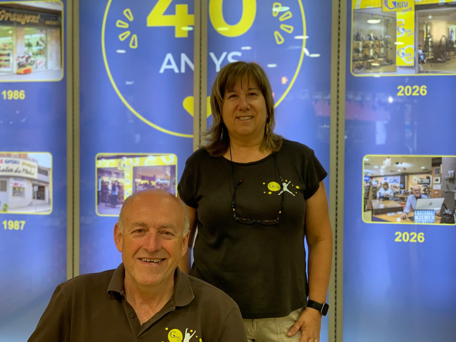 Núria Camps i Salvador Roca davant el cartell retroil·luminat que aquests dies presideix la sabateria de l'avinguda de Catalunya. FOTO: Judit Josa
