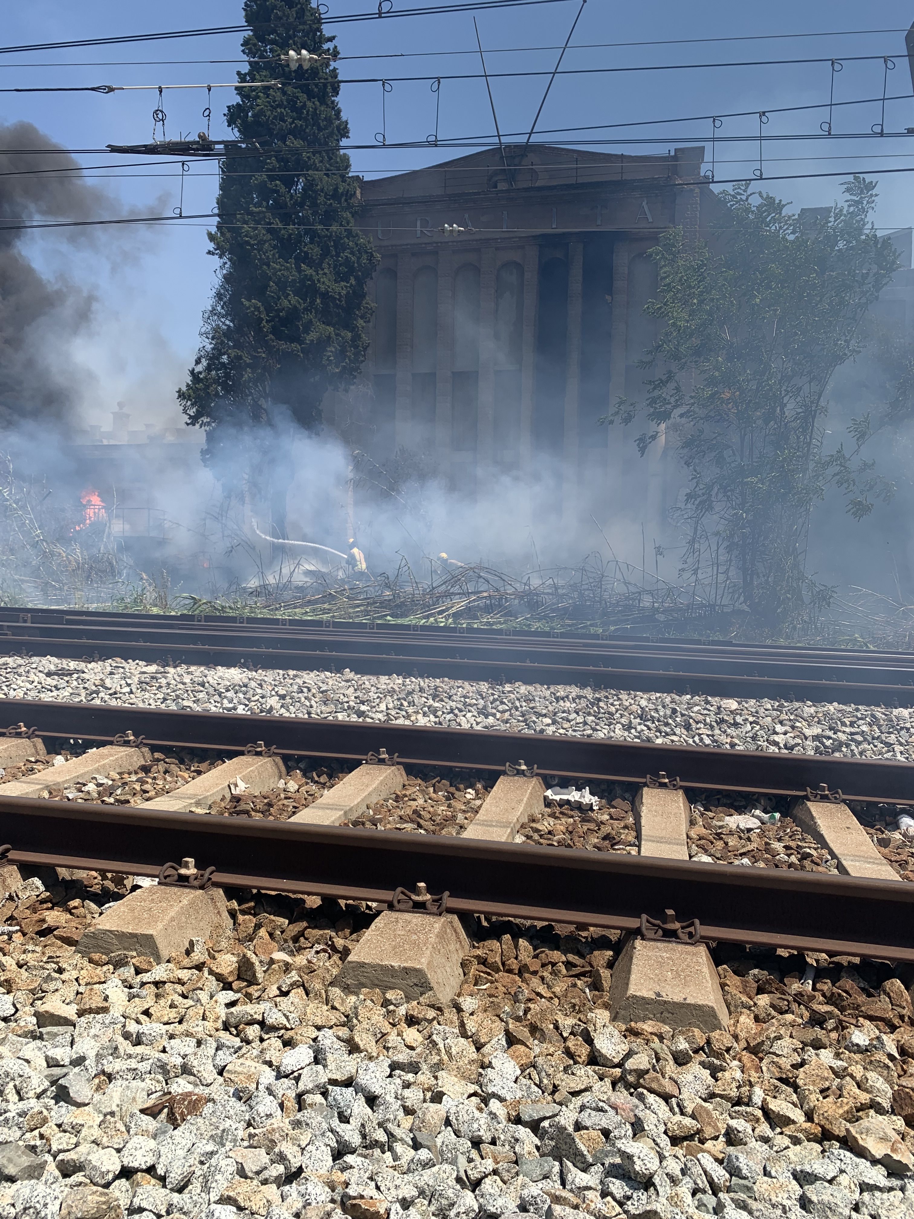 Les flames han cremat matolls a tocar de les vies, davant d’una de les naus històriques de la Uralita. FOTO: Judit Josa