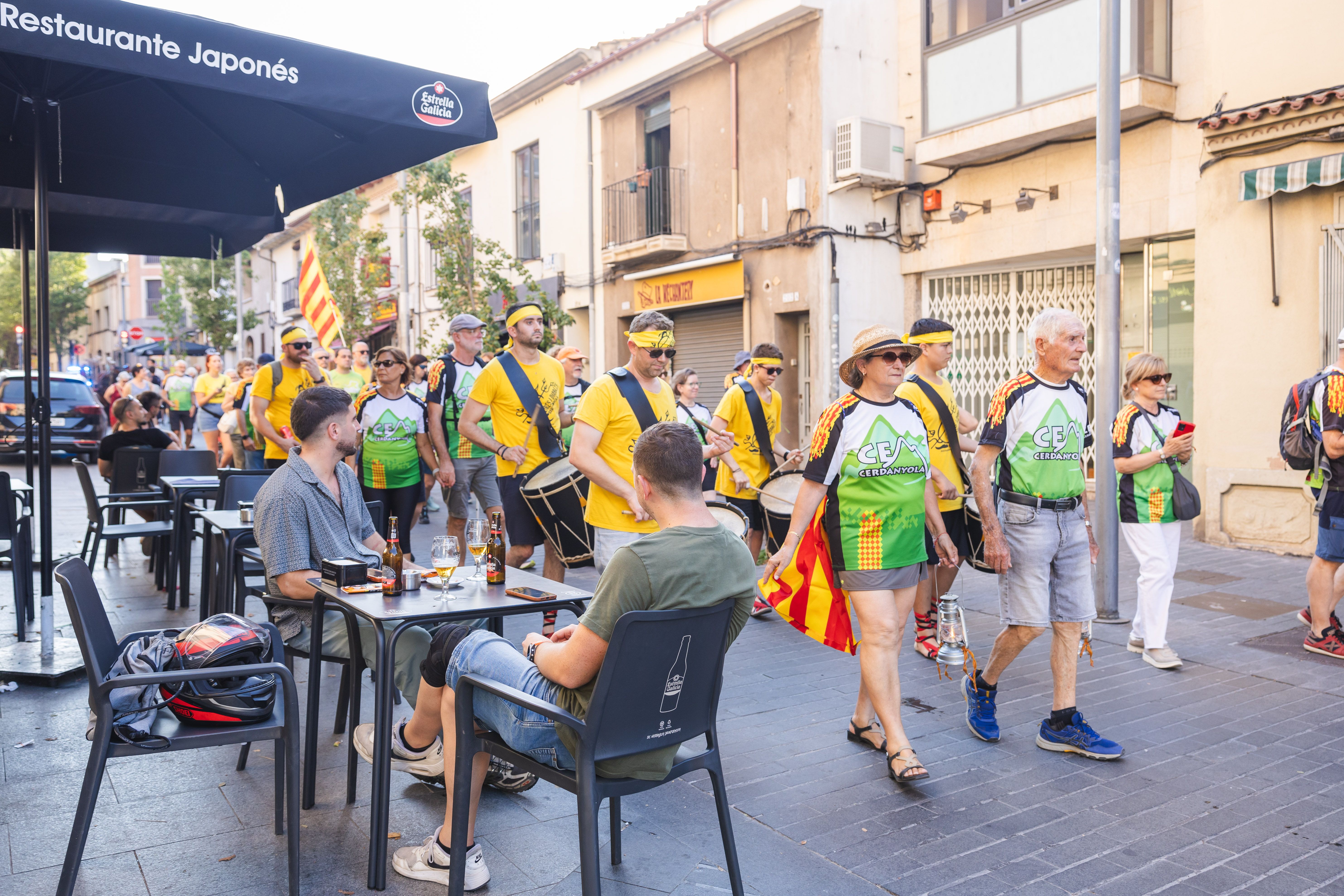 La cercavila travessa els carrers de Sant Ramon i Sant Martí entre terrasses i veïnat. FOTO: Arnau Padilla.