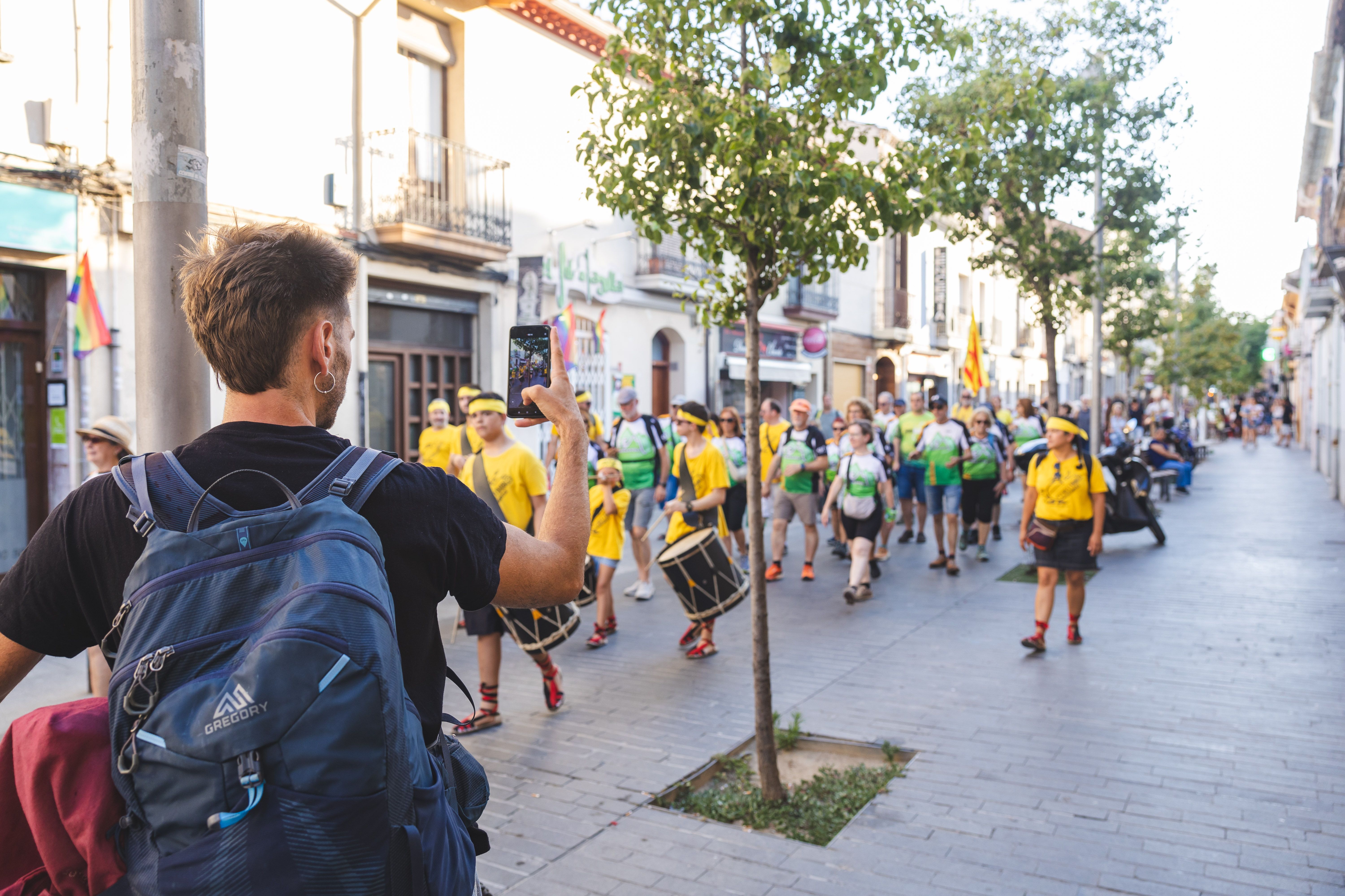 Un veí grava amb el mòbil el pas de la comitiva per Sant Ramon. FOTO: Arnau Padilla.