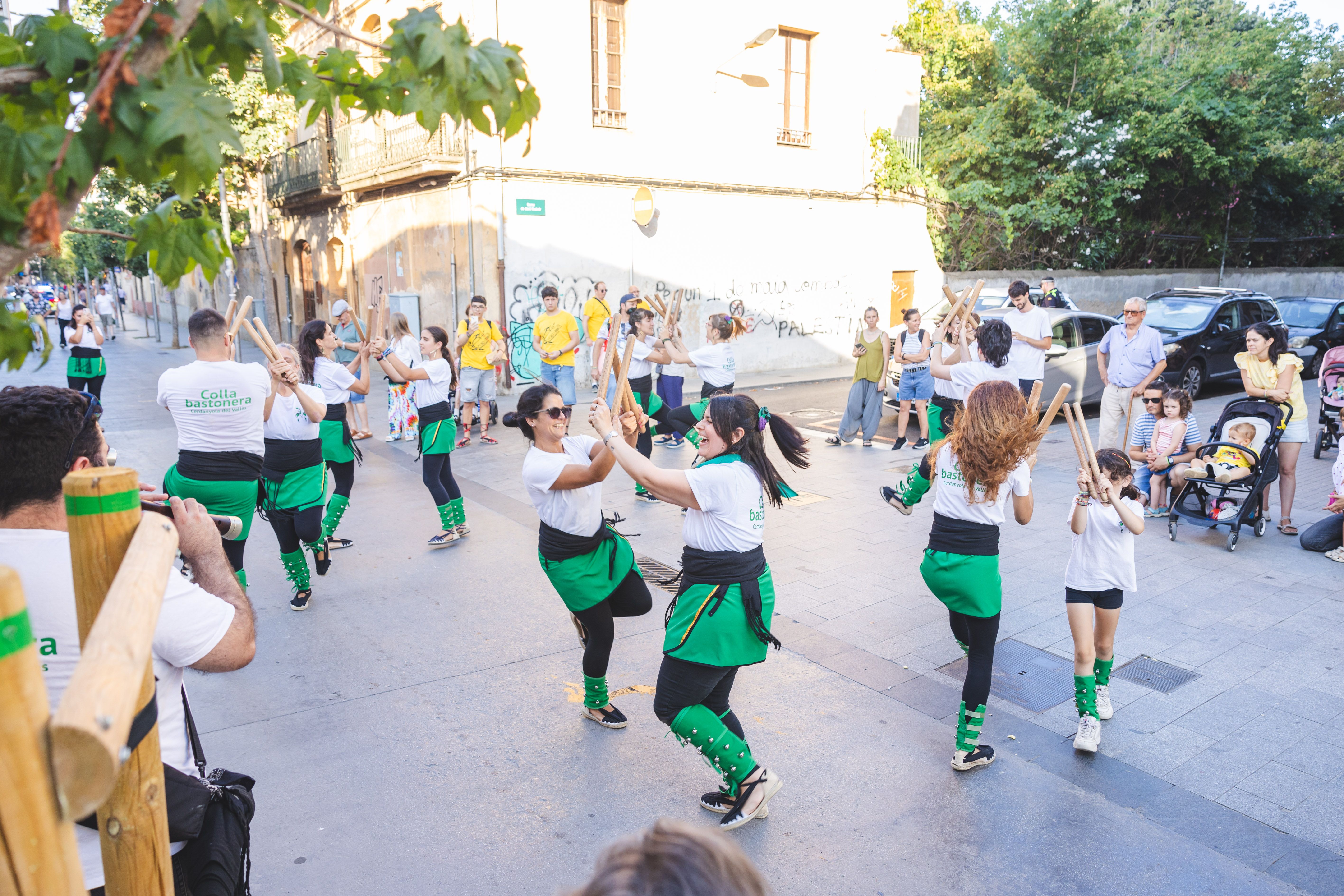 La Colla Bastonera balla durant el recorregut de la cercavila. FOTO: Arnau Padilla.